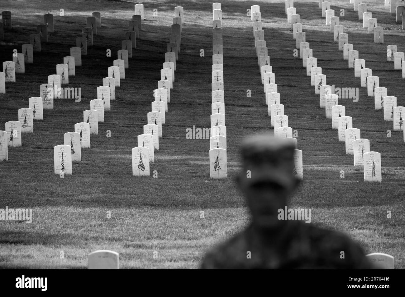 Soldiers place flags on graves at Arlington National Cemetery. Stock Photo