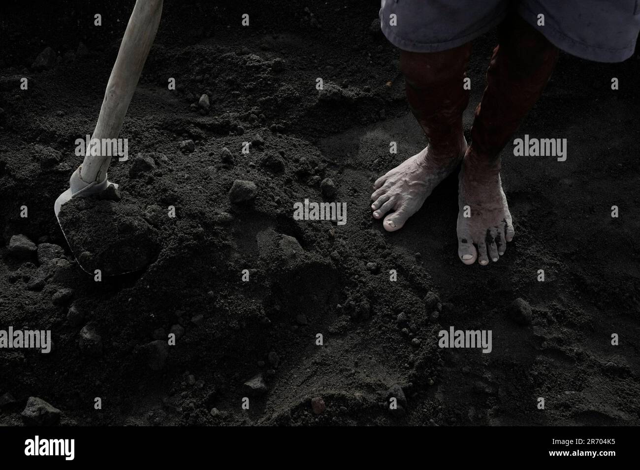 Joseph Martillana takes a break from work which earns him about 500 pesos  (about USD 9) a day for selling sand and gravel near the restive Mayon  Volcano in Daraga, Albay province,