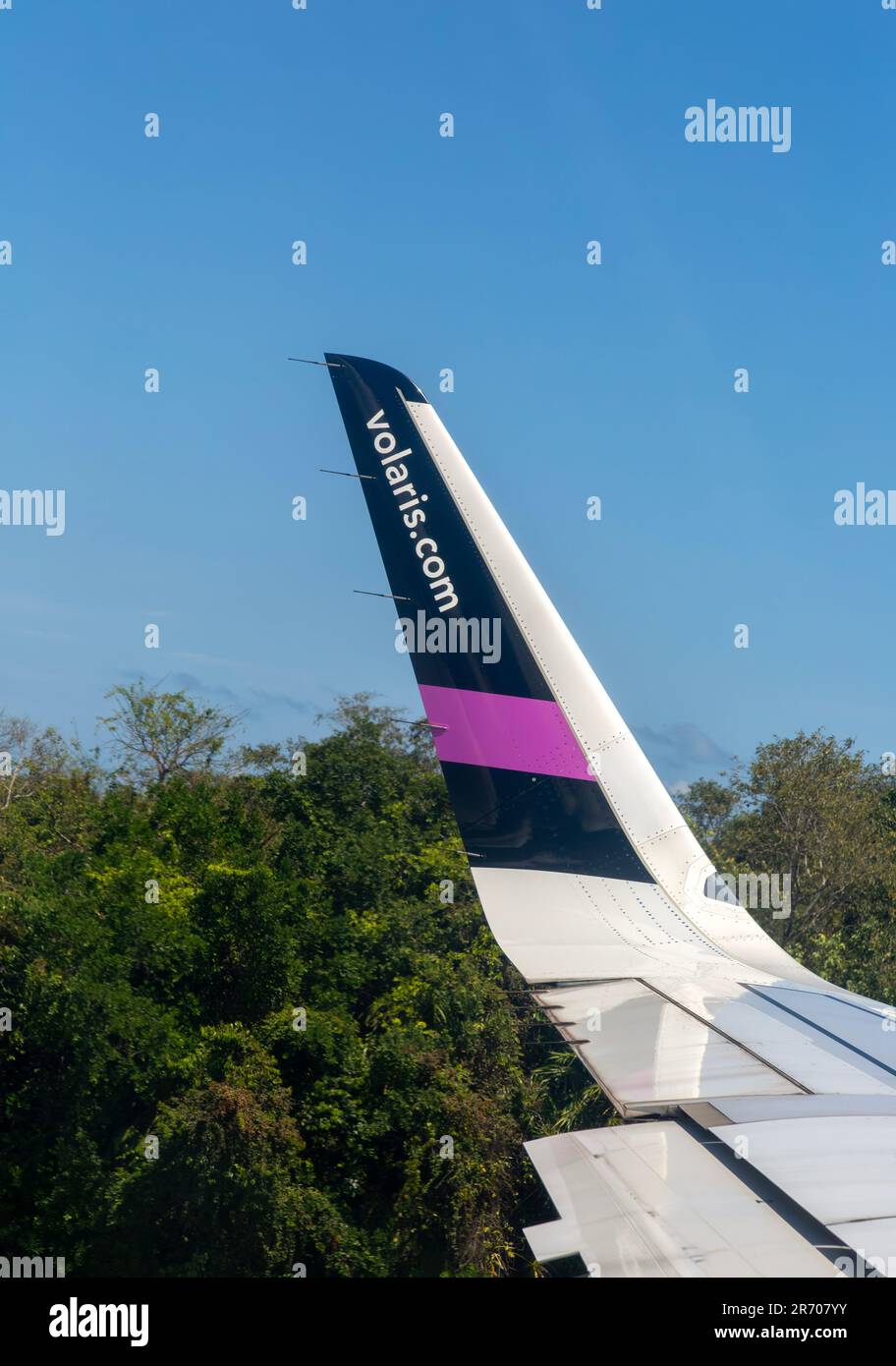 Tip of plane wing with and Volaris airline company colours