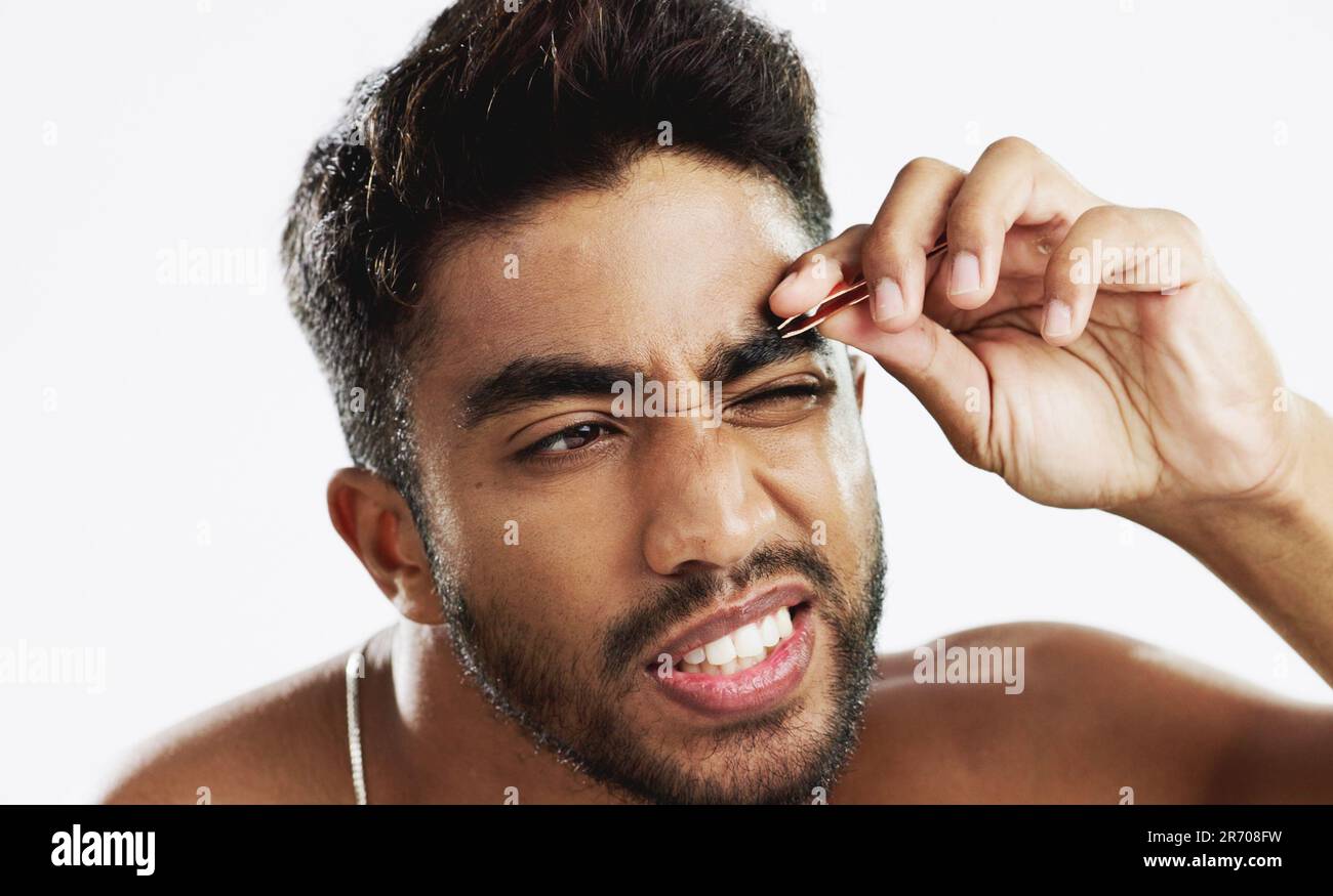 Man grooming his eyebrows with a tweezer in studio for self care, beauty  and cleanliness. Hair removal, tweezing and male model from India doing  Stock Photo - Alamy