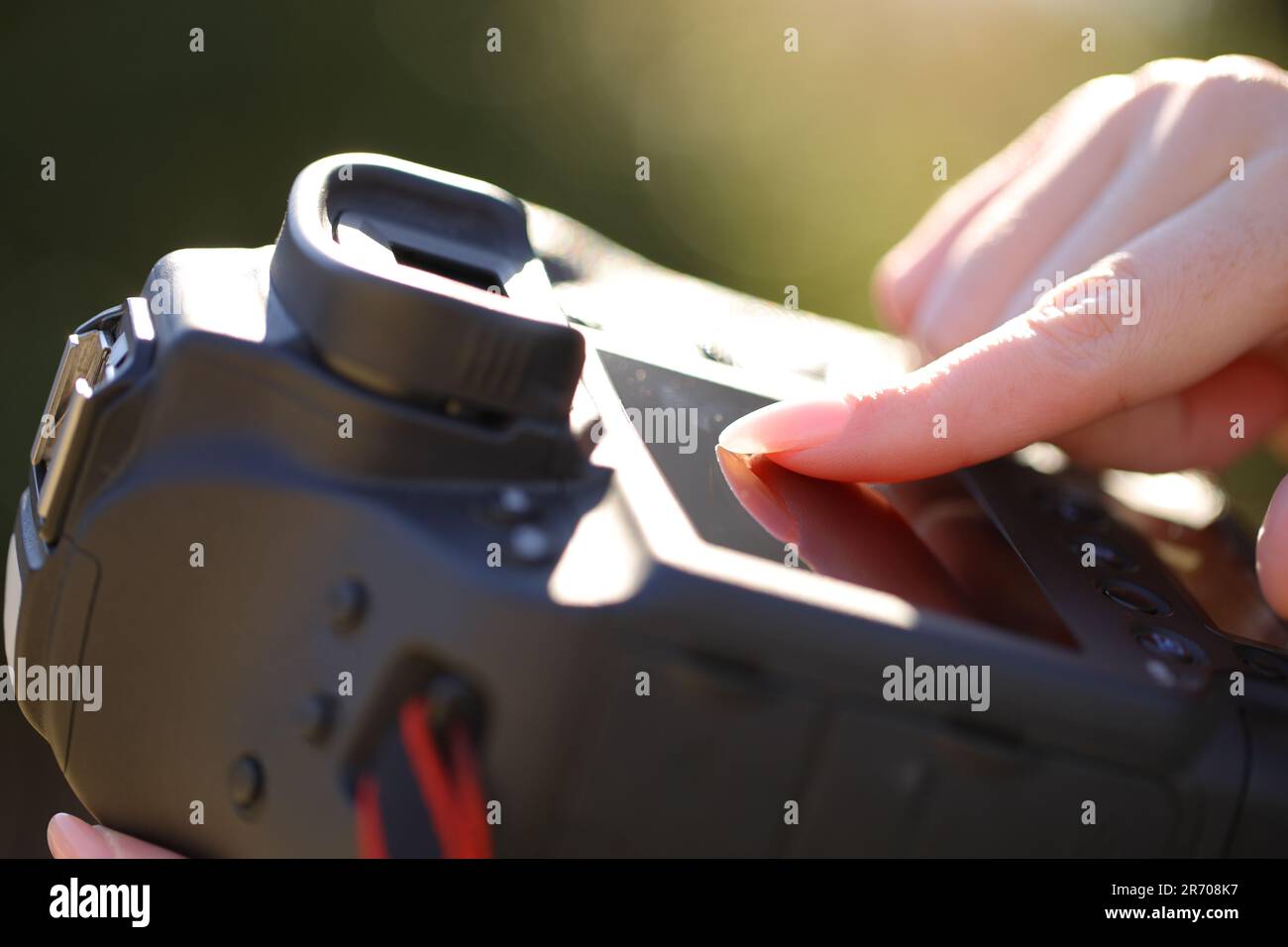 Close up portrait of a photographer finger using touch screen on professional camera Stock Photo