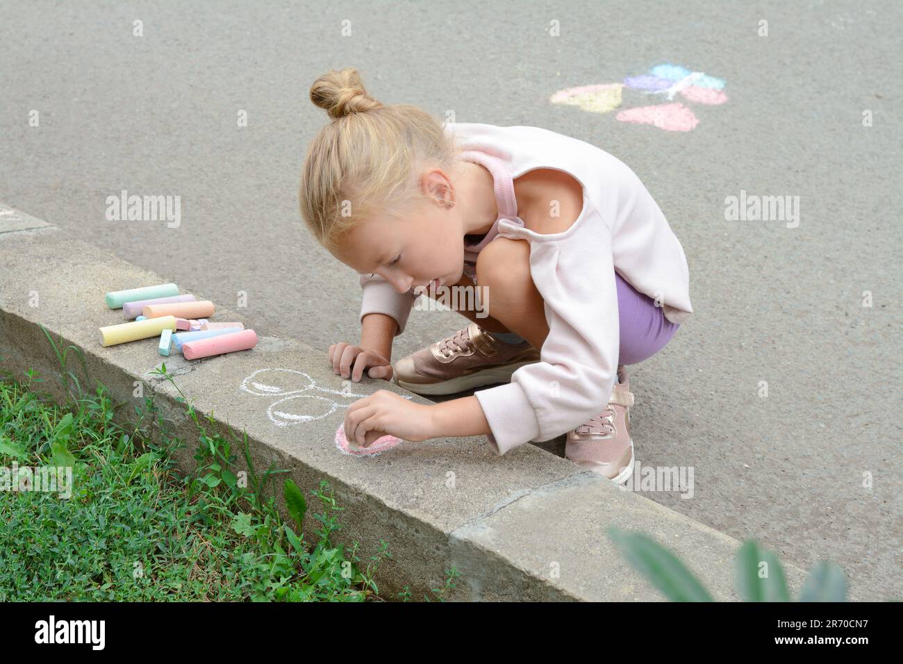Little child drawing balloons with chalk on asphalt Stock Photo - Alamy