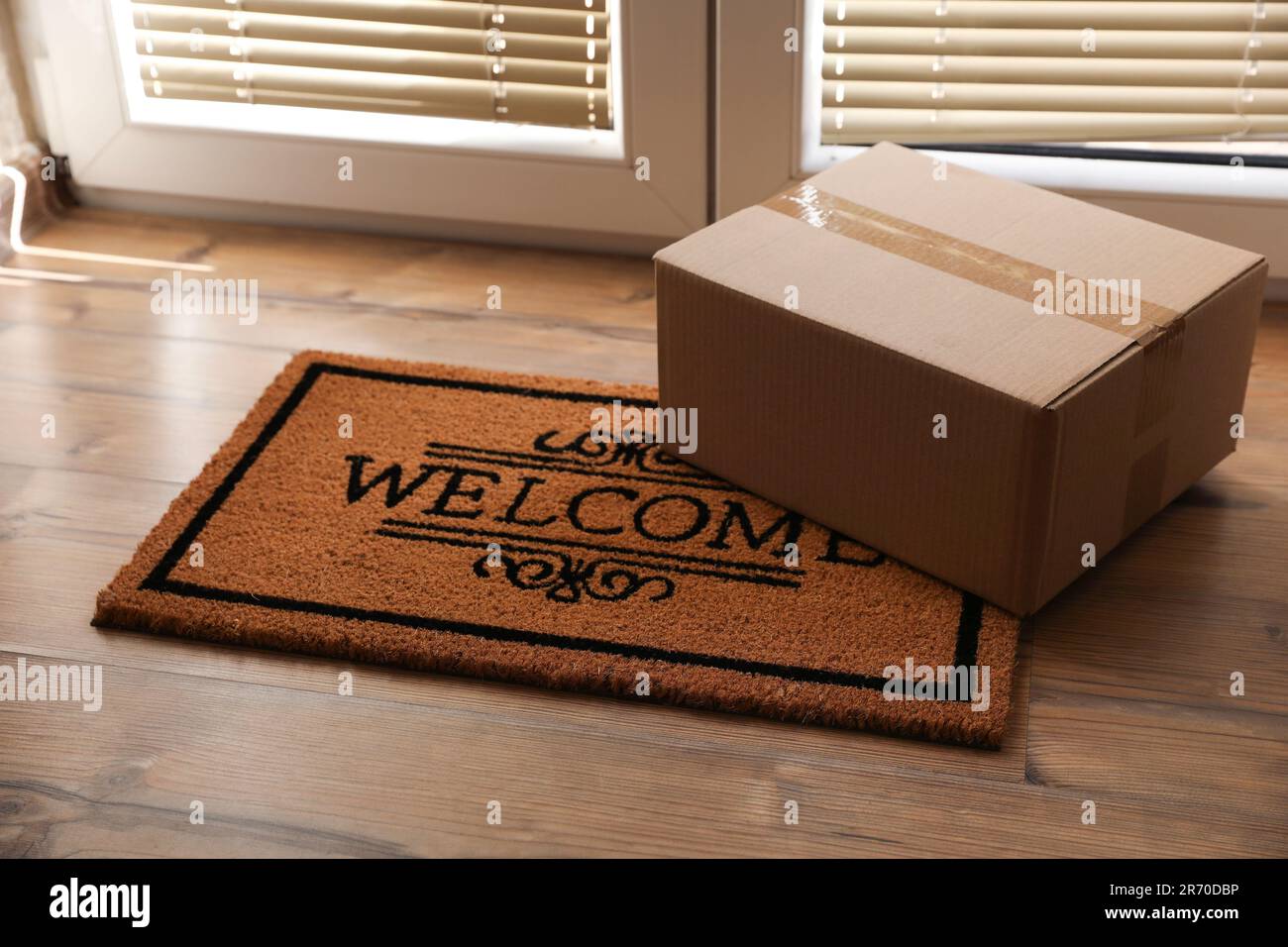 Parcel on mat near front door indoors Stock Photo