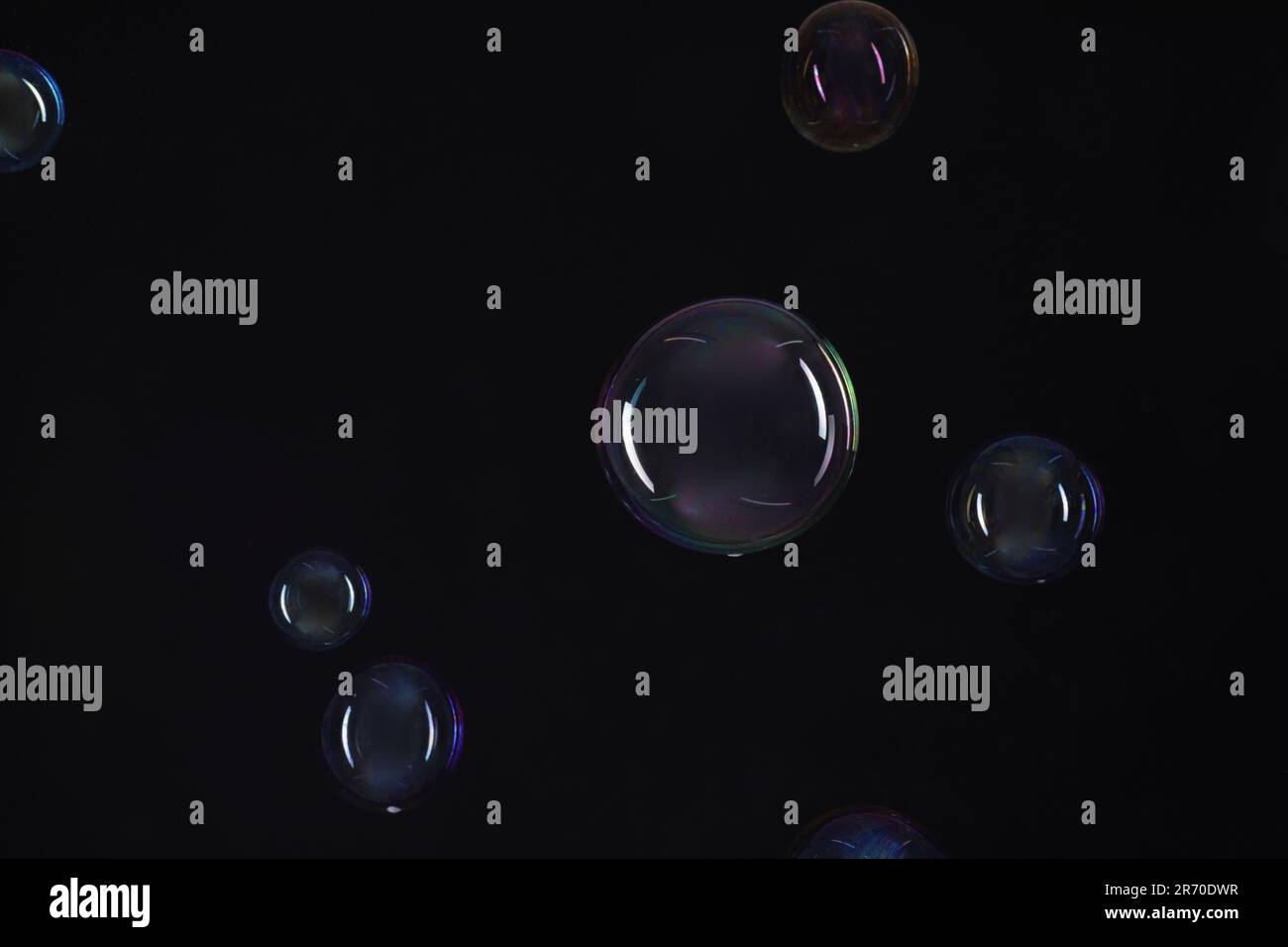 Many beautiful soap bubbles on black background Stock Photo - Alamy
