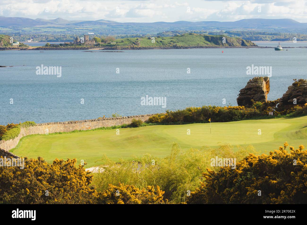 Scenic view of coastal golf hole and green and the Firth of Forth with the histoic Inchcolm Abbey and the Pentland Hills from Fife, Scotland Stock Photo