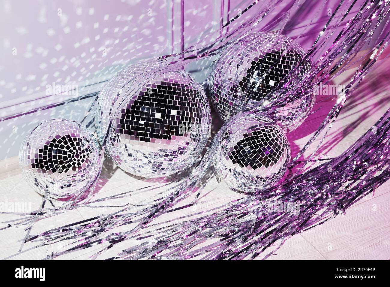 Shiny disco balls and foil fringe curtain indoors, color toned Stock