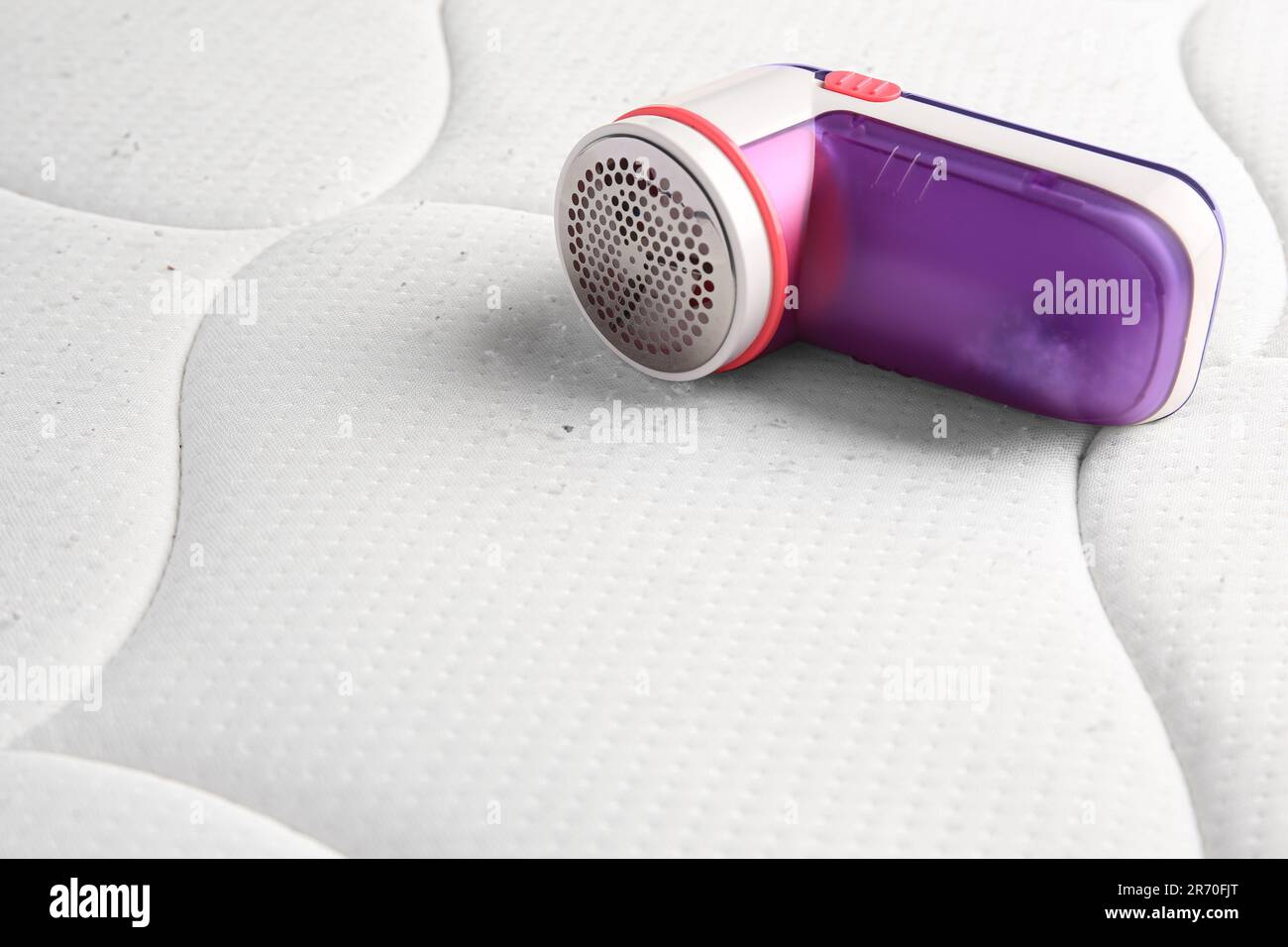Fabric shaver on mattress with lint. Space for text Stock Photo Alamy