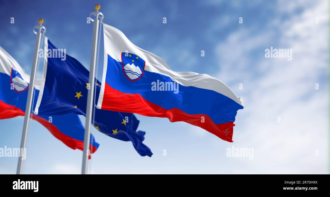 The flags of Slovenia and the European Union fluttering together on a clear day. Slovenia has been a member of the eurozone since January 1, 2007. 3D Stock Photo