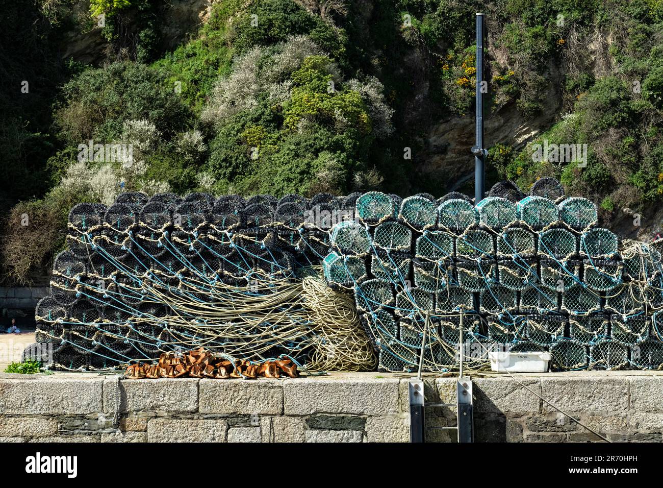 Lobster pots used for catchig lobster and crabs are stacked on the harbourside. The traps are drying in warm sunshine Stock Photo
