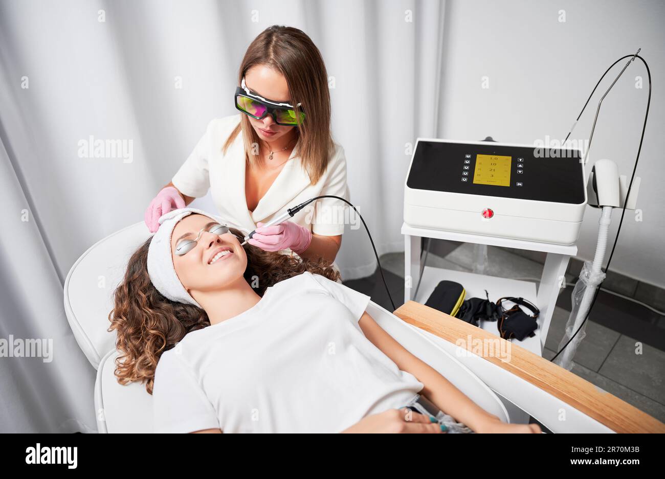 Woman cosmetologist painlessly and quickly removing telangiectasias