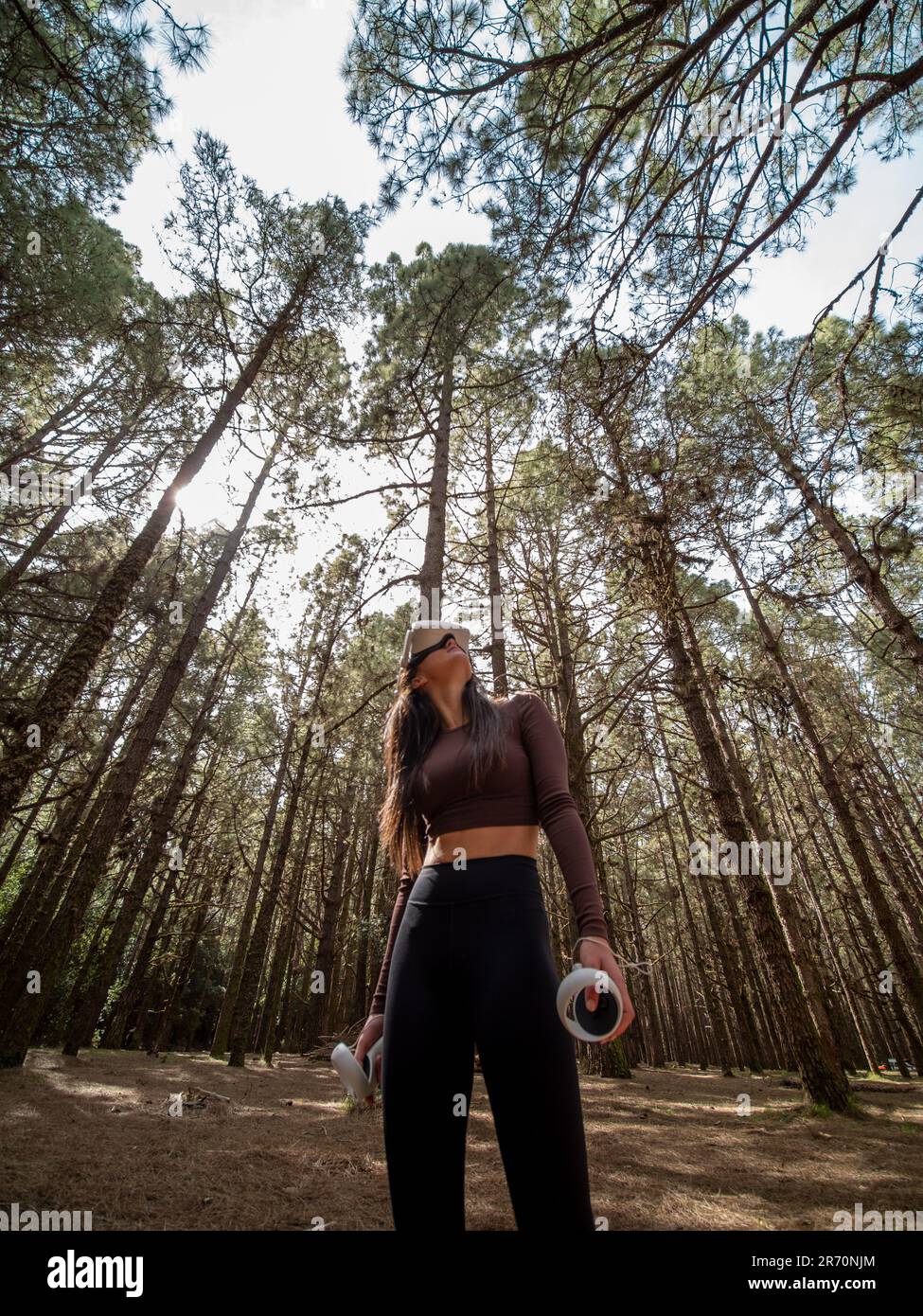 A girl playing Virtual Reality in the woods, featuring trees in the ...