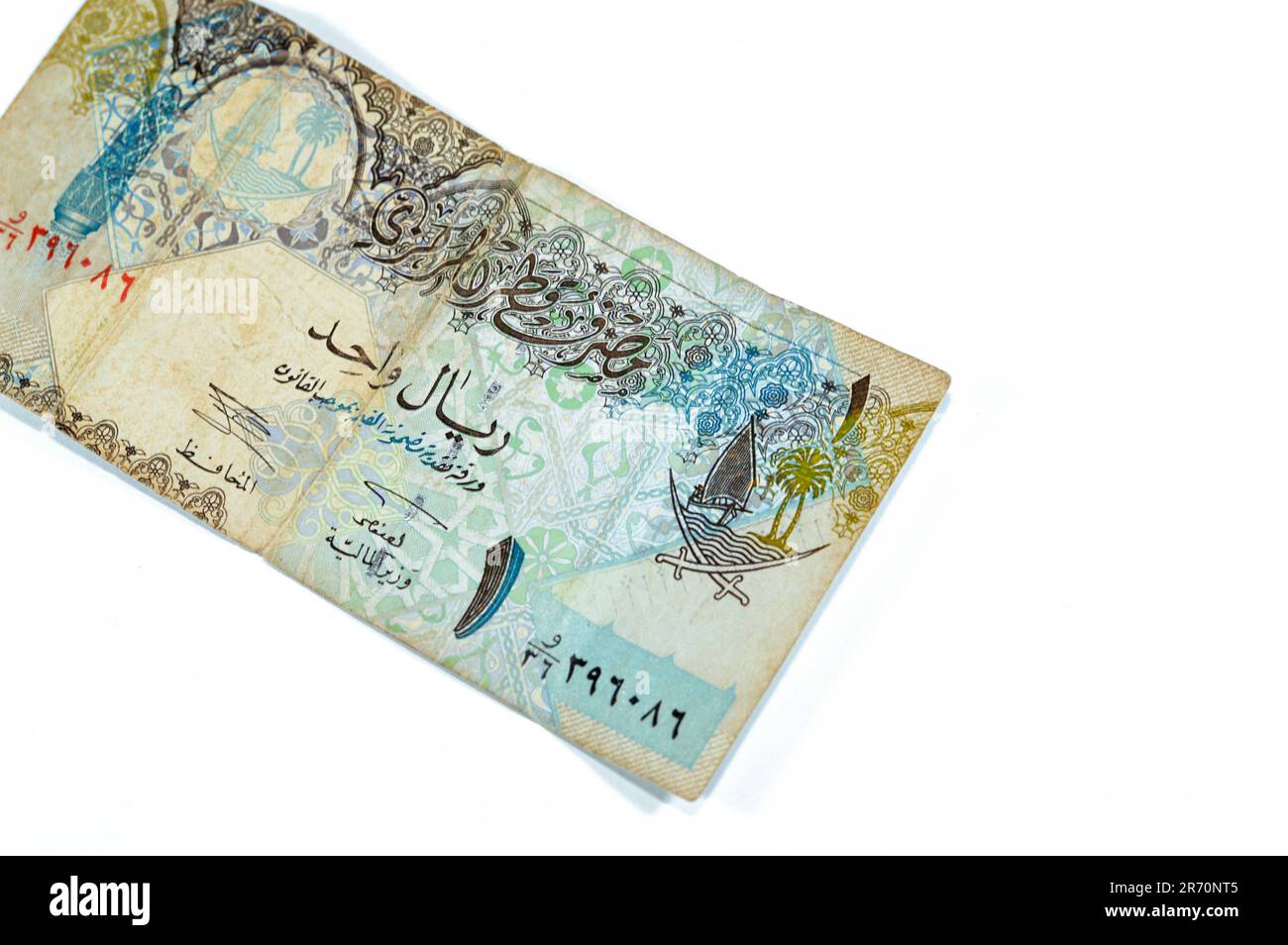 obverse side of 1 Qatari Riyal cash money currency of Qatar banknote features Ornated column, arches, sailboats, palm trees, crossed swords, vintage r Stock Photo