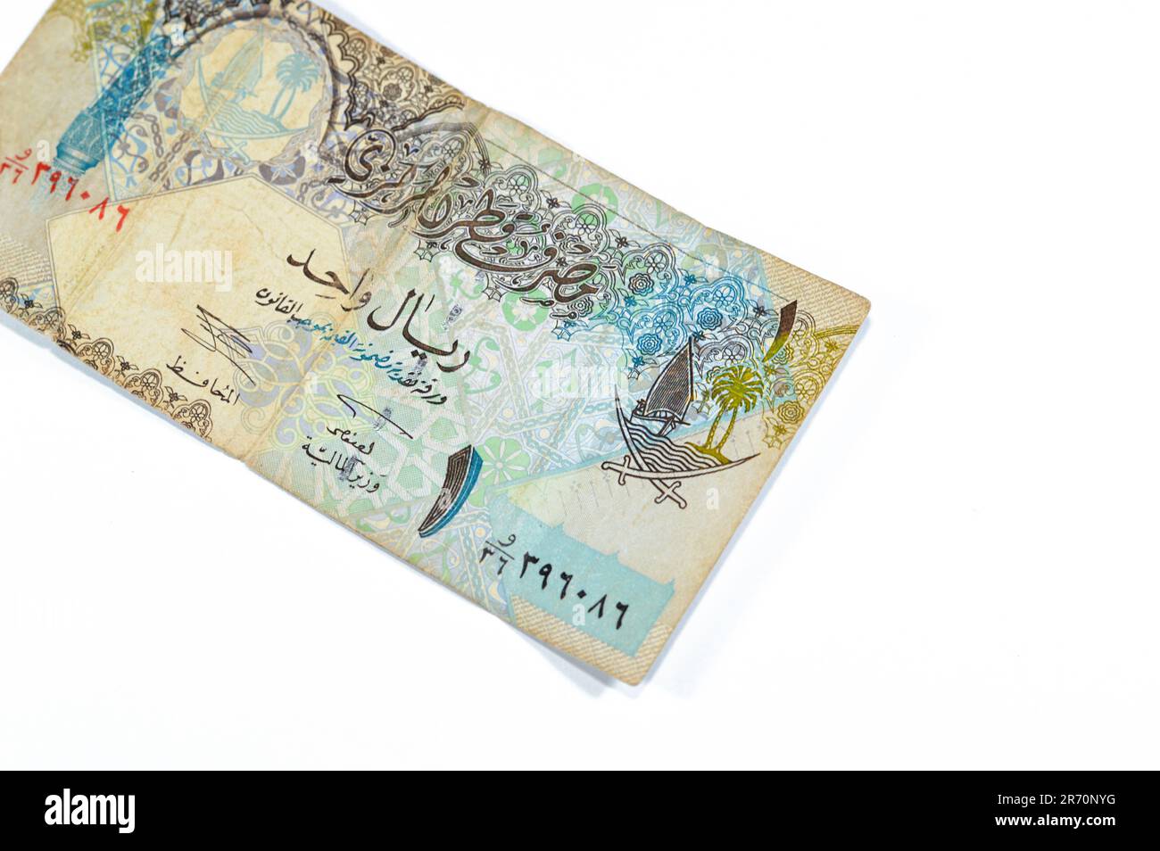 obverse side of 1 Qatari Riyal cash money currency of Qatar banknote features Ornated column, arches, sailboats, palm trees, crossed swords, vintage r Stock Photo