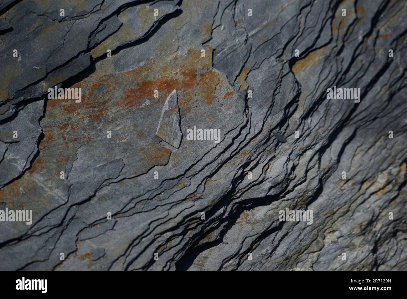 A close-up view of a grey, chiseled stone, with a smooth, polished surface Stock Photo