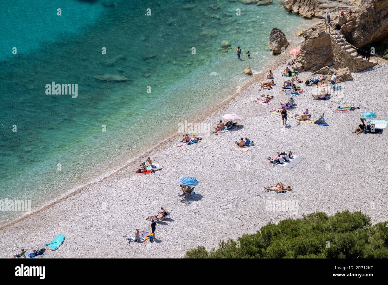 The Beautiful beach of Platja Granadella Alicante in Spain with people sunbathing Stock Photo