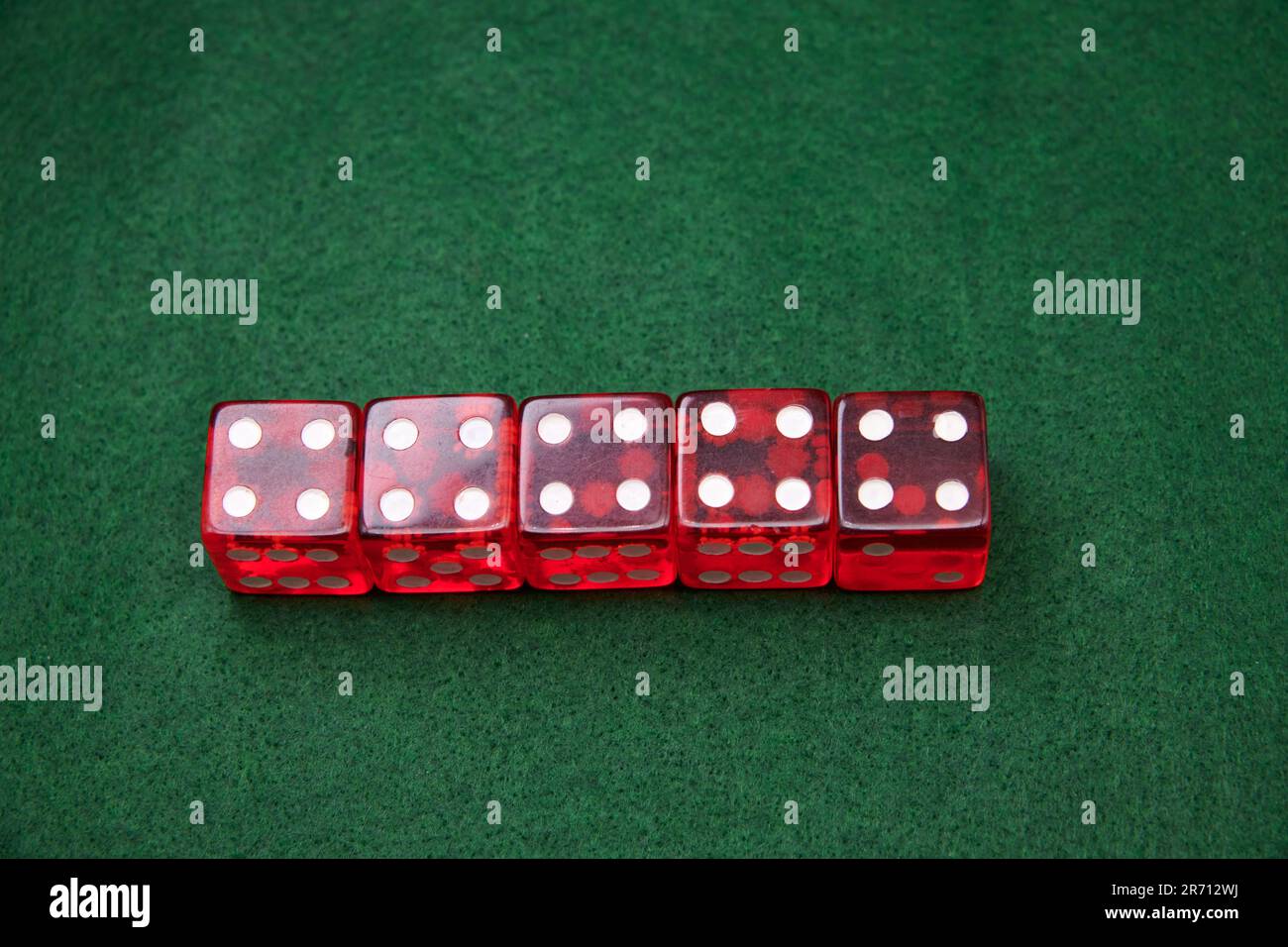 Red Dice on a green baize tabletop Stock Photo