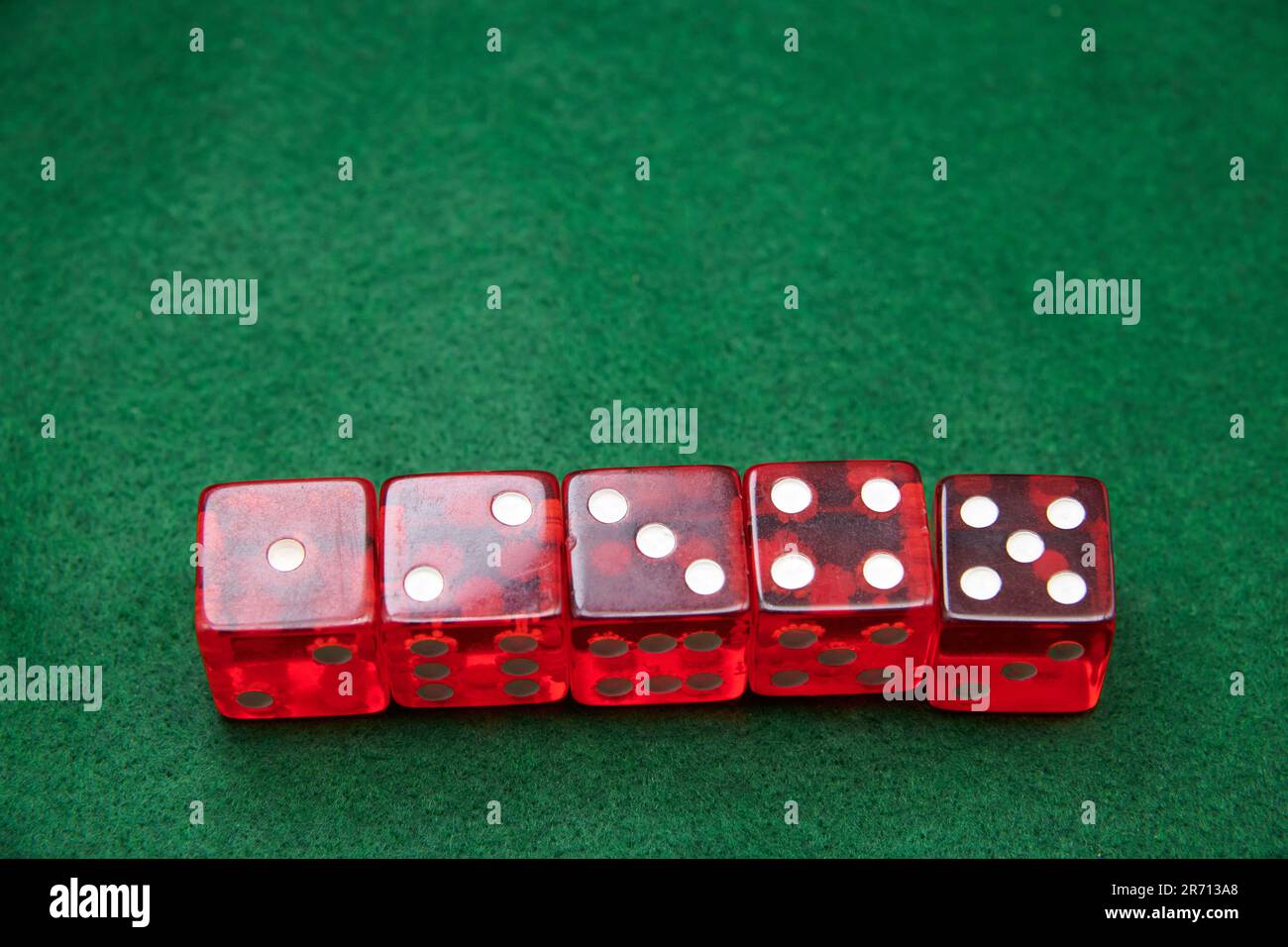 Red Dice on a green baize tabletop Stock Photo