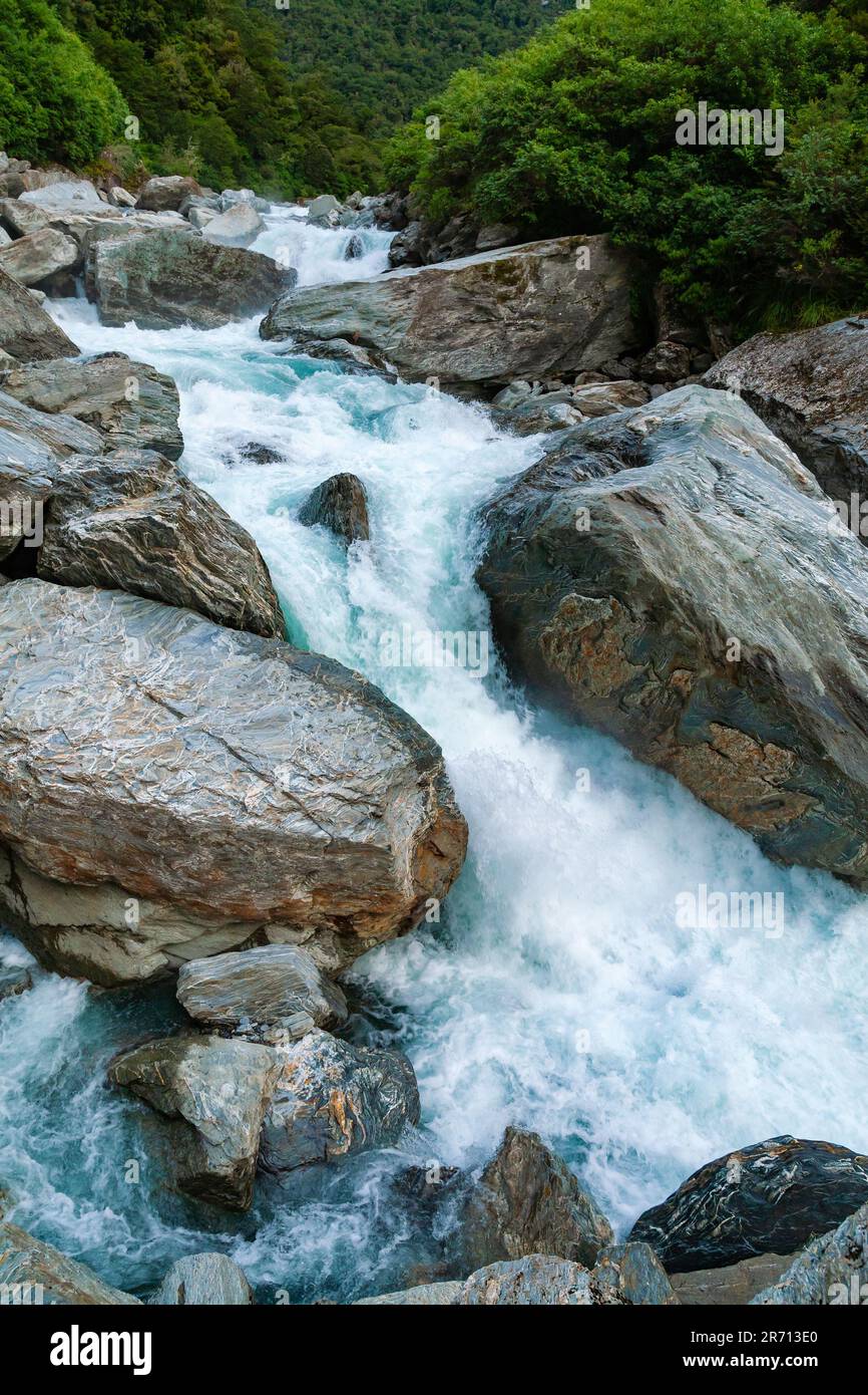 Milky blue glacier waters of Haast River at Gates of Haast gorge in Mount Aspiring National Park, South Island of New Zealand Stock Photo