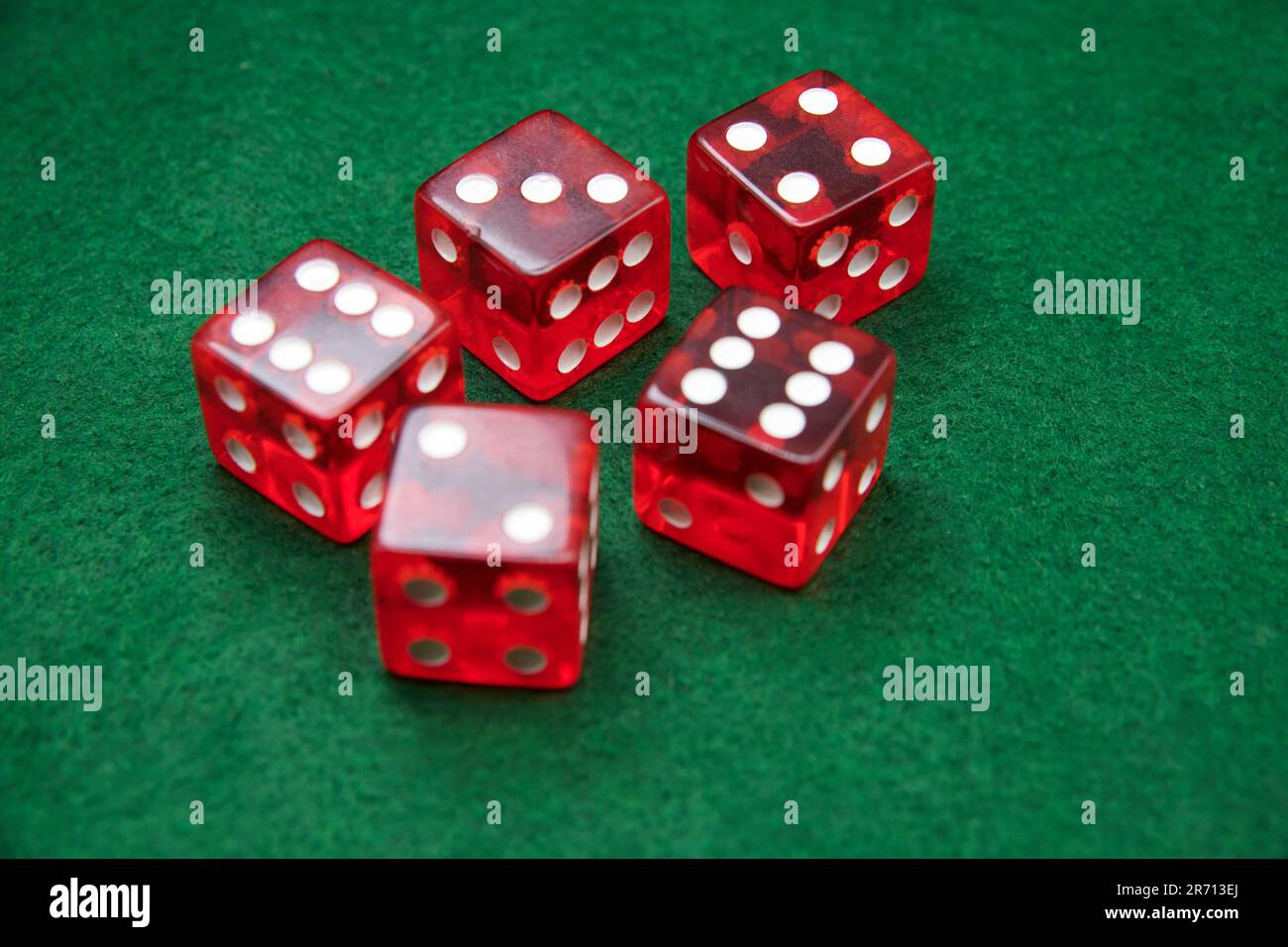 Red Dice on a green baize tabletop Stock Photo