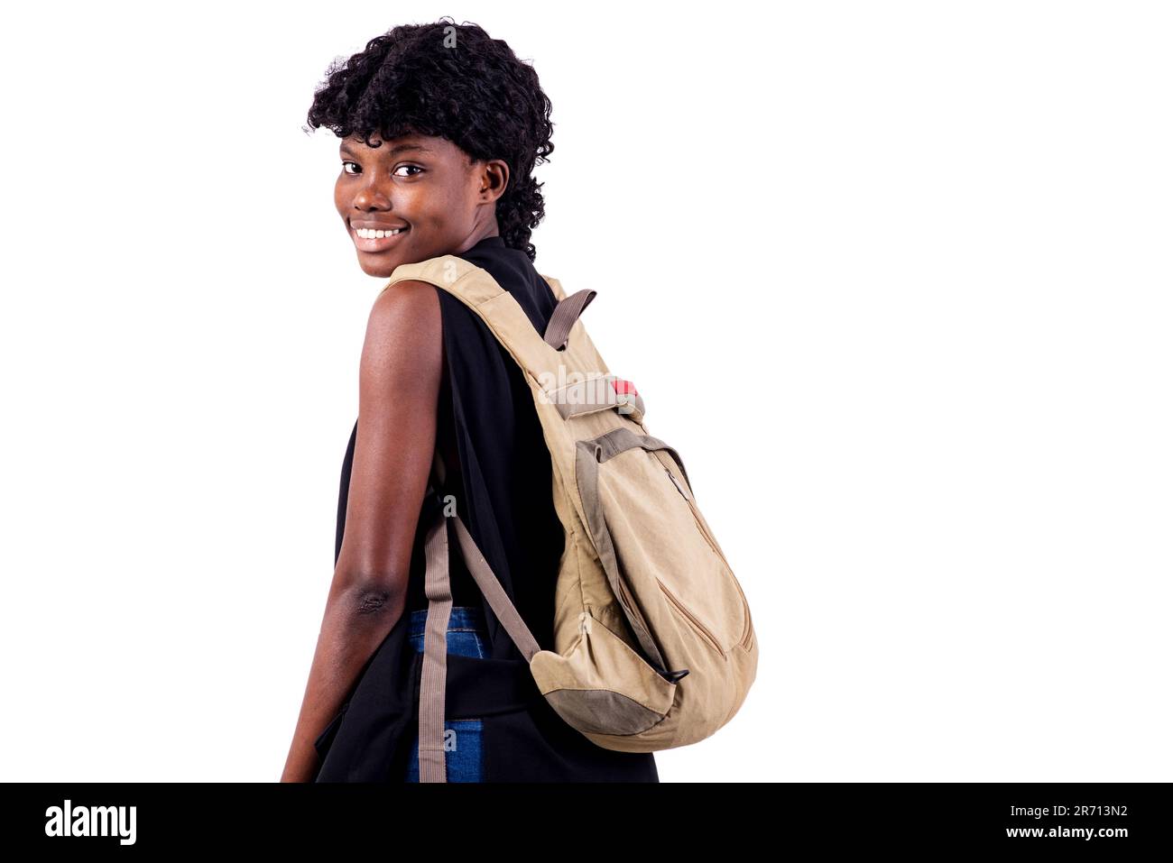 young student girl carrying a backpack while smiling at the camera ...
