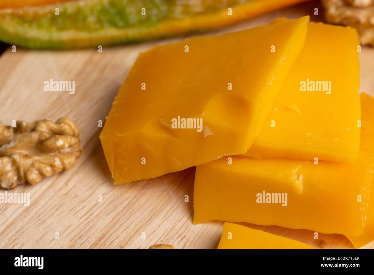 Sliced hard cheese made from milk, real aged yellow cheese on a board