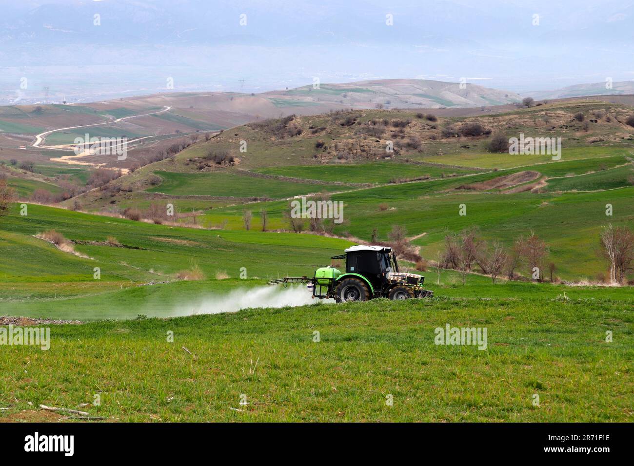 Farmer spraying with tractor in the field Stock Photo