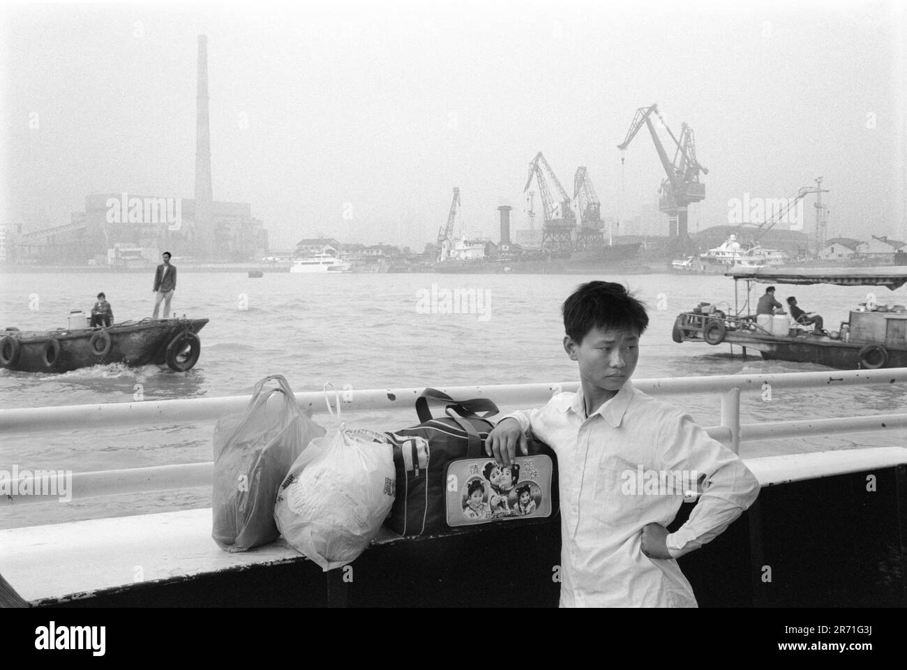 Shanghai China 2000.  There are still numerous ferries that cross the Huangpu river and until the late 1980s was the only way to reach Pudong.  The ferries go every 10 minutes, take about 10 minutes, and cost 50 mao. This young traveller has on his bag pictures of Princess Huan Zhu from the highly popular film of the same name Huan Zhu Ge-Ge (1999); a Hong Kong-China production.  This is one of those films that has everything - action, comedy, songs, historical drama; and all the most interesting characters (good and bad) are female...2000s HOMER SYKES Stock Photo