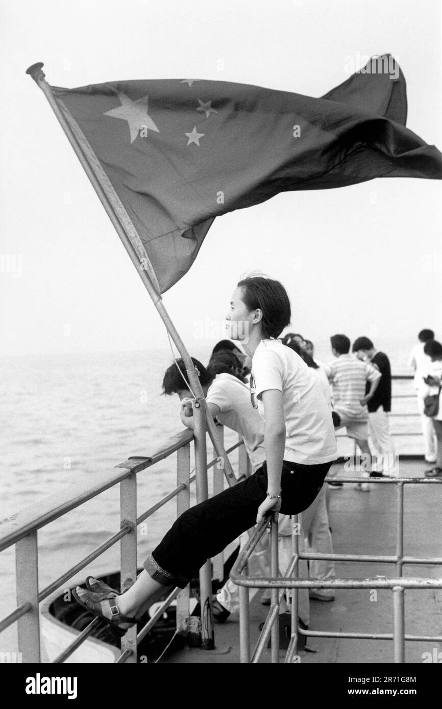 Shanghai China 2000.  A young girl travels back to her studies in Shanghai from her parents’ home on Chongming Island. The silt-created island at the mouth of the Yangzi is famous for its small and  very tasty crabs available in the local restaurants.  They breed out at sea but live in the fresh water of the many rivers and inlets on the island. 2000s HOMER SYKES Stock Photo