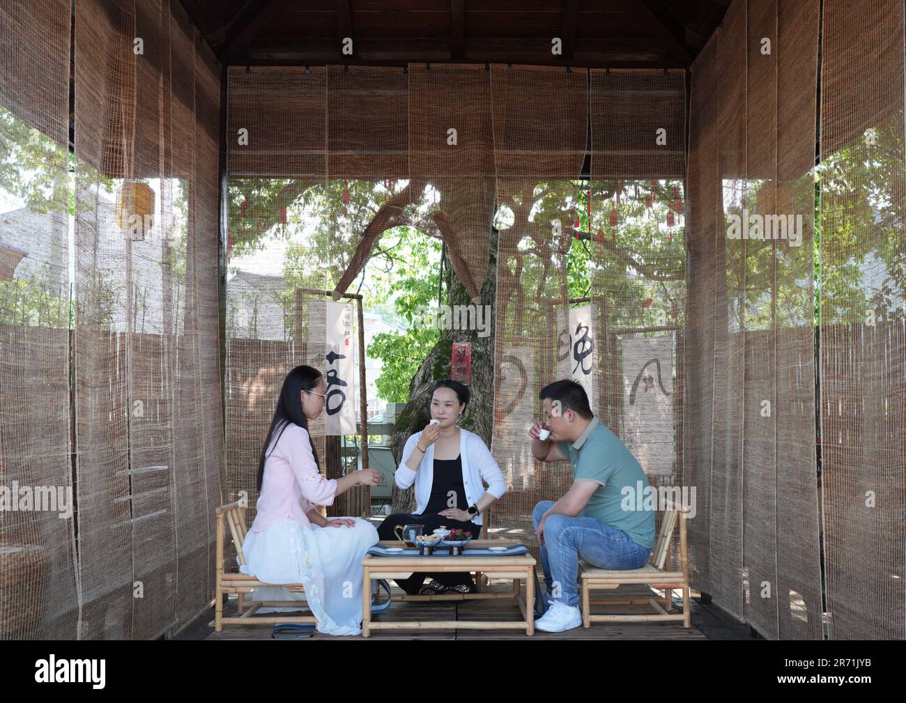 (230612) -- HANGZHOU, June 12, 2023 (Xinhua) -- People have tea at a teahouse beside the Baima Lake in Yiting Town of Shaoxing, east China's Zhejiang Province, June 9, 2023.  In June 2003, Zhejiang launched the Green Rural Revival Program, which plans to renovate about 10,000 incorporated villages and transform about 1,000 central villages among them into examples of moderate prosperity in all respects.   Thanks to the program, the image of the countryside has been comprehensively lifted in Zhejiang Province. A total of 2,170 featured villages and over 3 million beautiful rural courtyards have Stock Photo