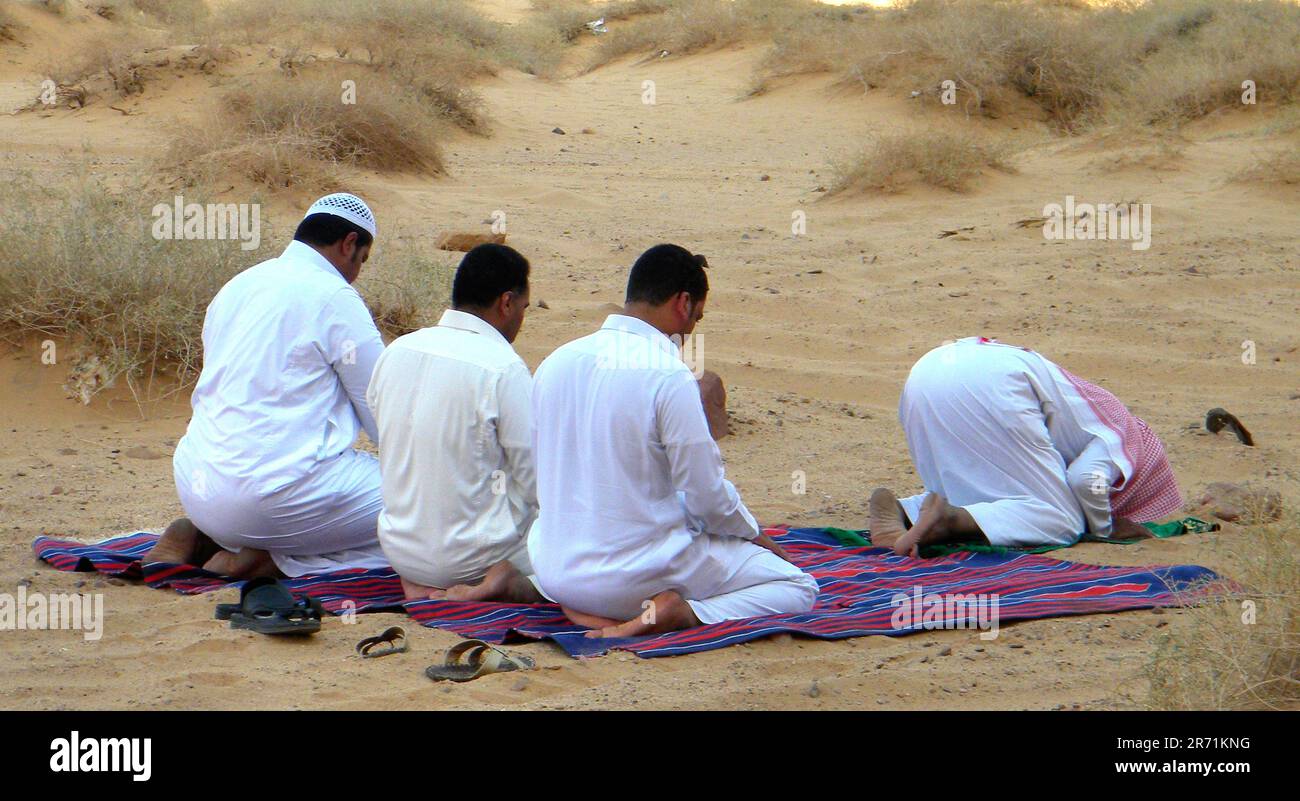 Bedouins during the prayer. Arabian desert. Saudi Arabia Stock Photo