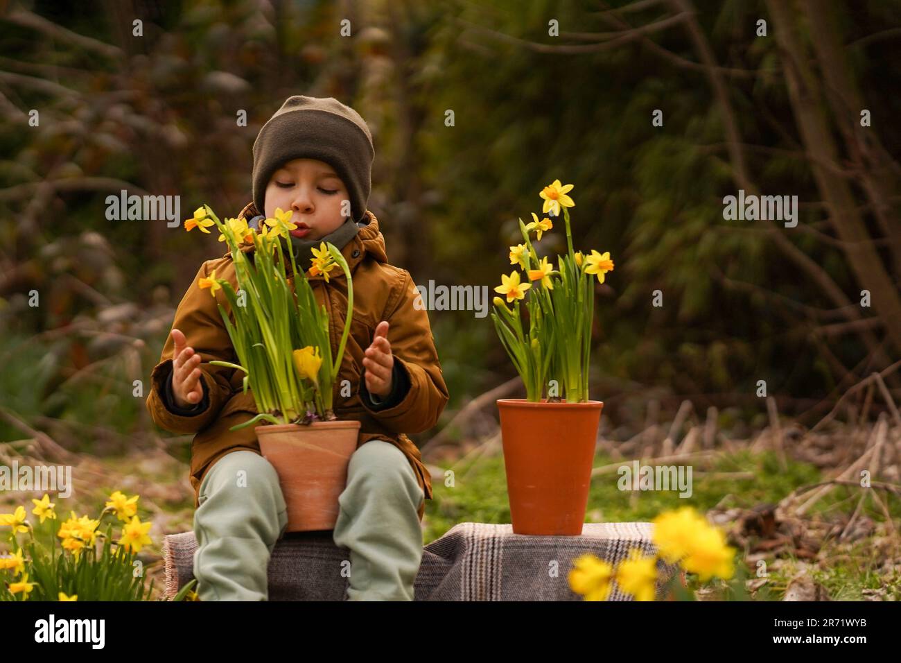 The boy takes care of the flowers. The child takes care of the