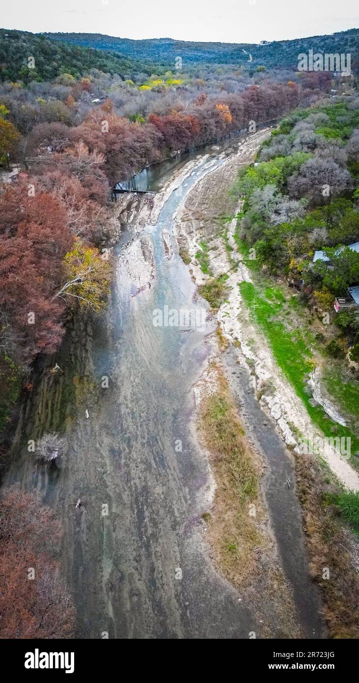 An Aerial view of a tranquil river, surrounded by lush green forests ...