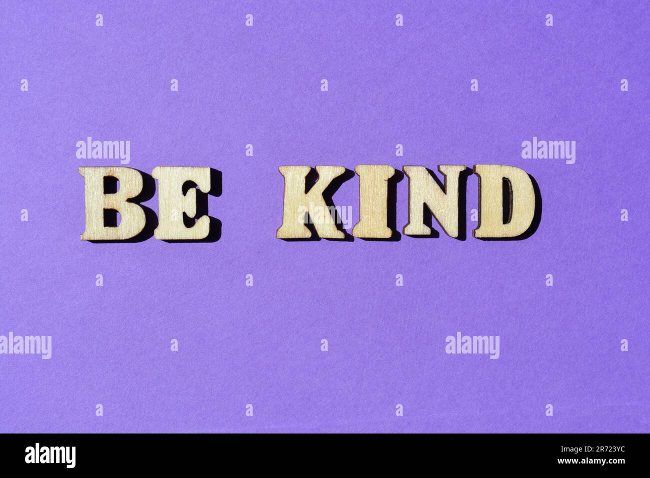 Be Kind, words in wooden alphabet letters isolated on purple background