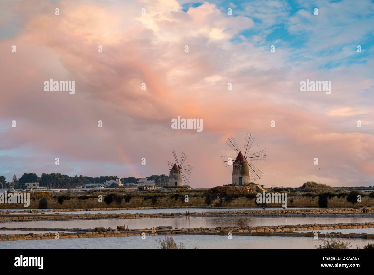 Sunset at the salt flats with the old windmill, saline dello Stagnone. Marsala, Trapani, Sicily, Italy, Europe. Stock Photo