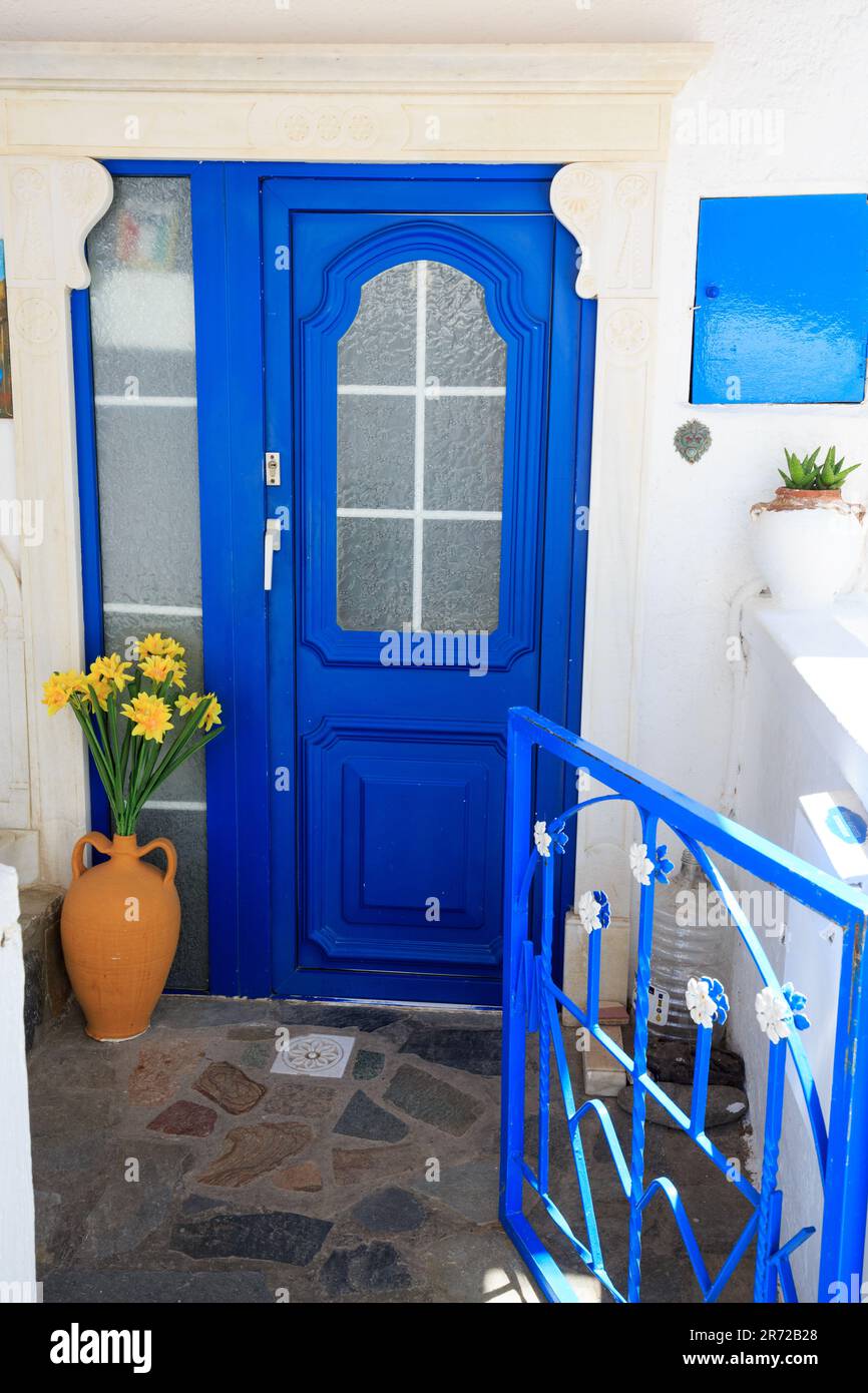 Bright blue door against a whitewashed wall, with gate open in Geece Stock Photo