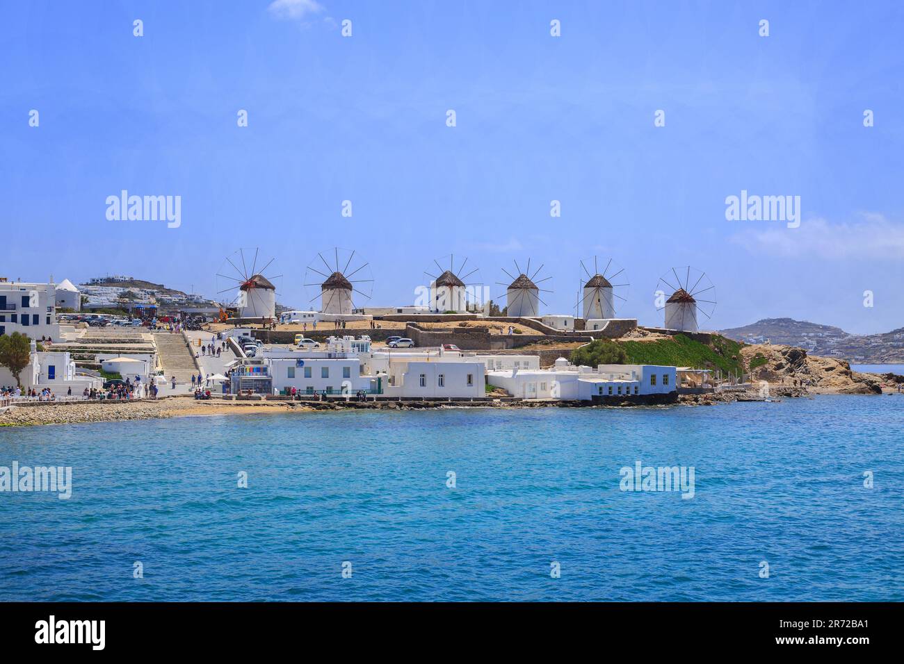 Landscape view of the Famous white windmills on the Island of Mykonos, with the Aegean sea glistening below. Stock Photo