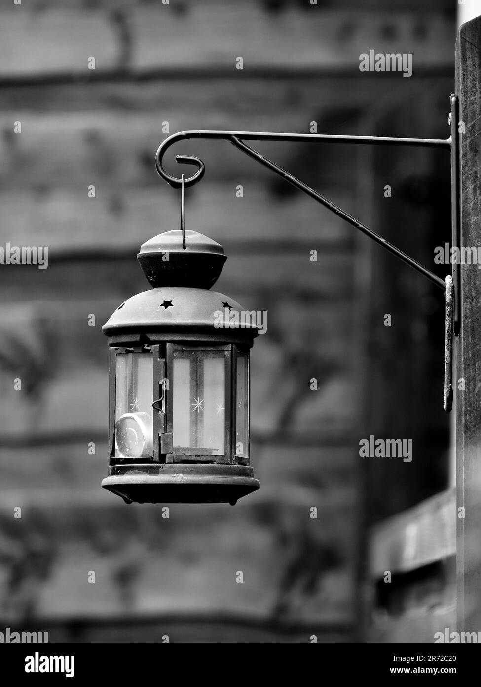 Lantern lamp hanging from a hook on the Wall monochrome image Stock Photo