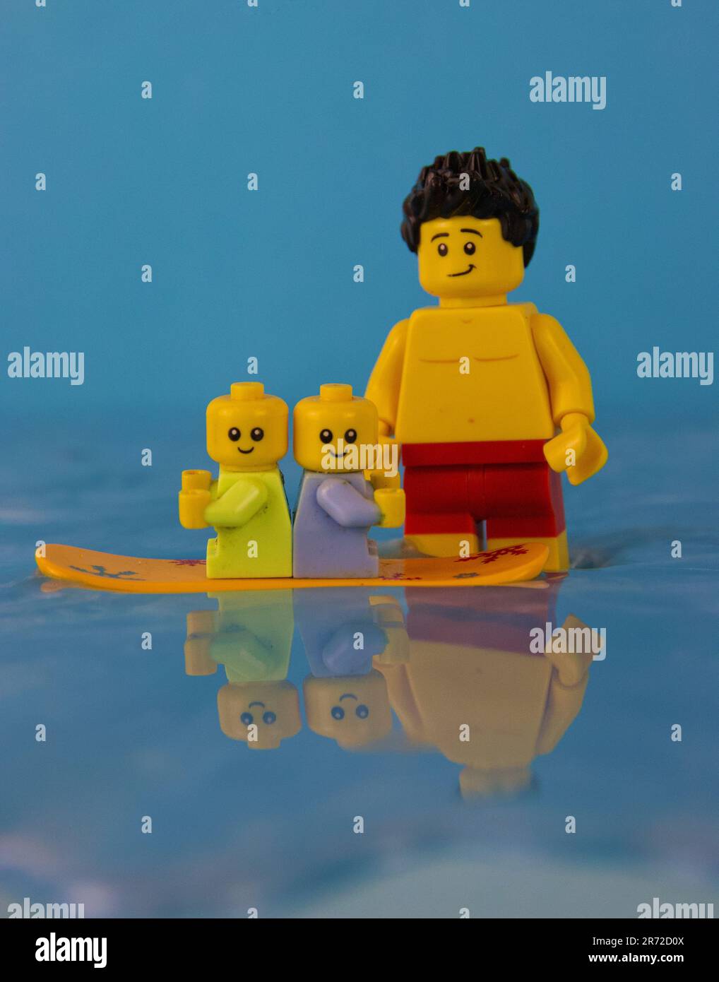 A family of LEGO figures and toys seated atop a floating board in a