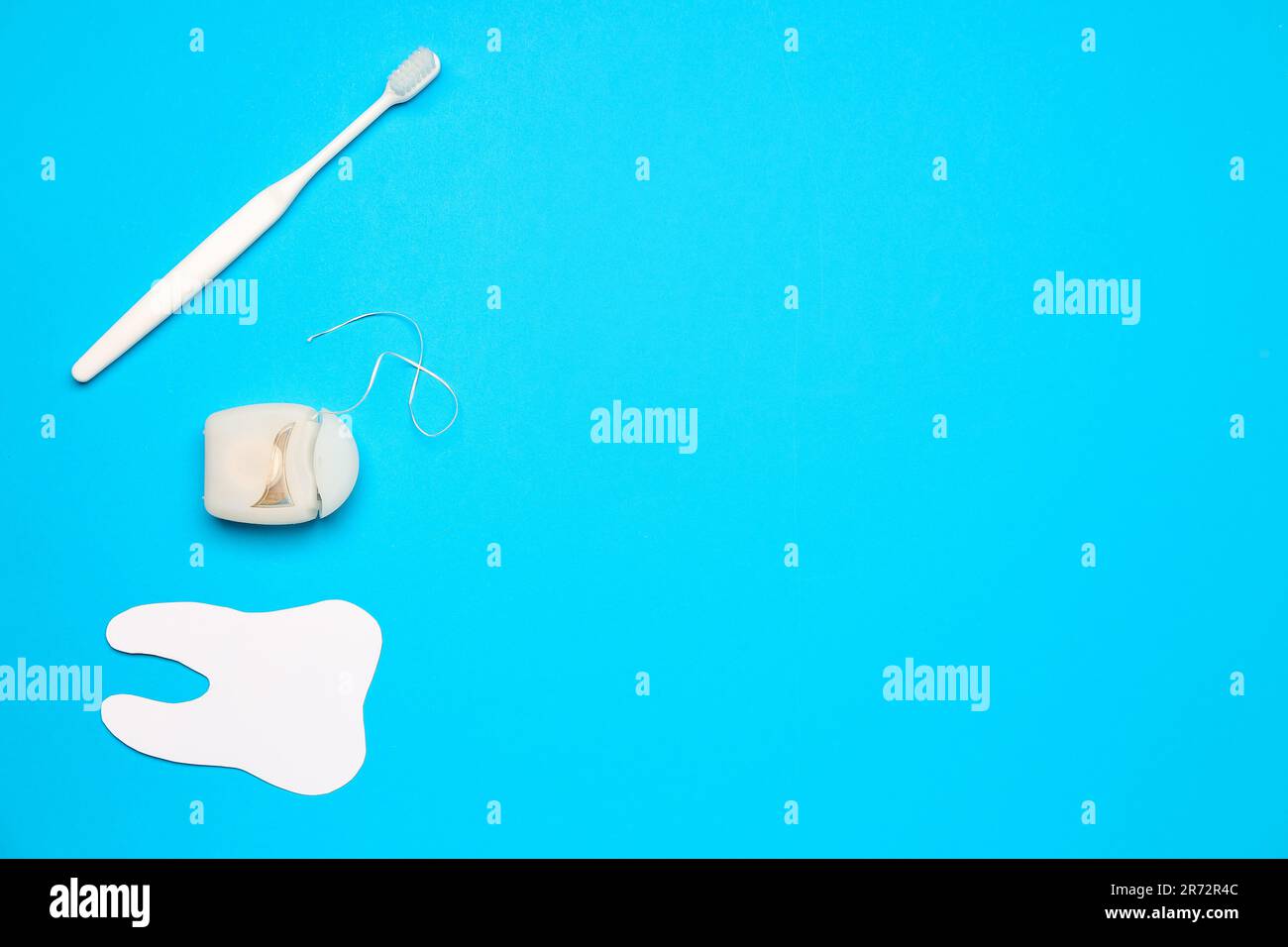 Dental floss, model of tooth and brush on blue background Stock Photo ...