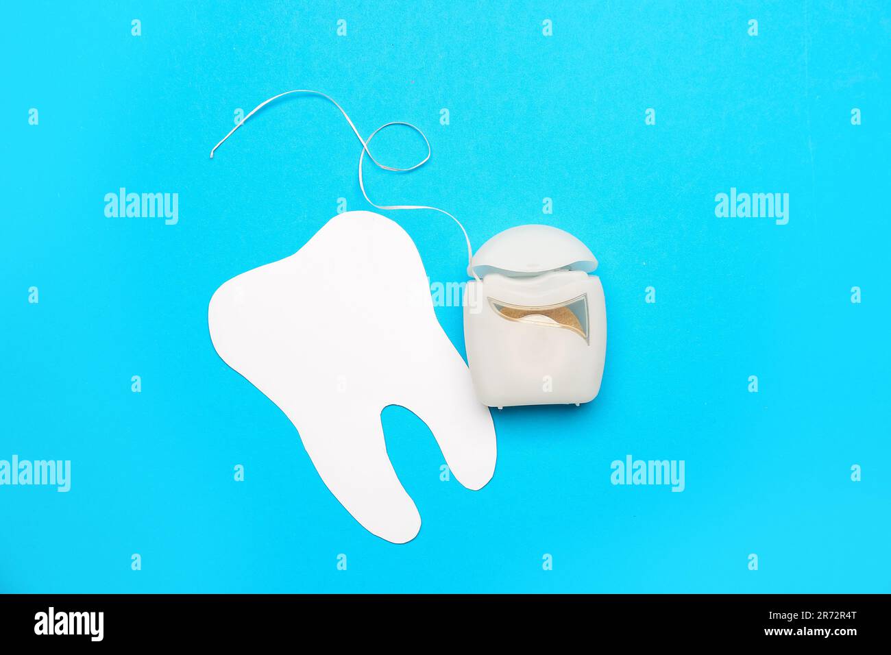 Case with dental floss and model of tooth on blue background Stock ...
