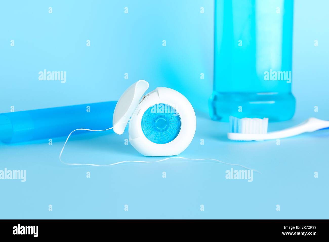 Dental floss and toothbrush on blue background Stock Photo - Alamy
