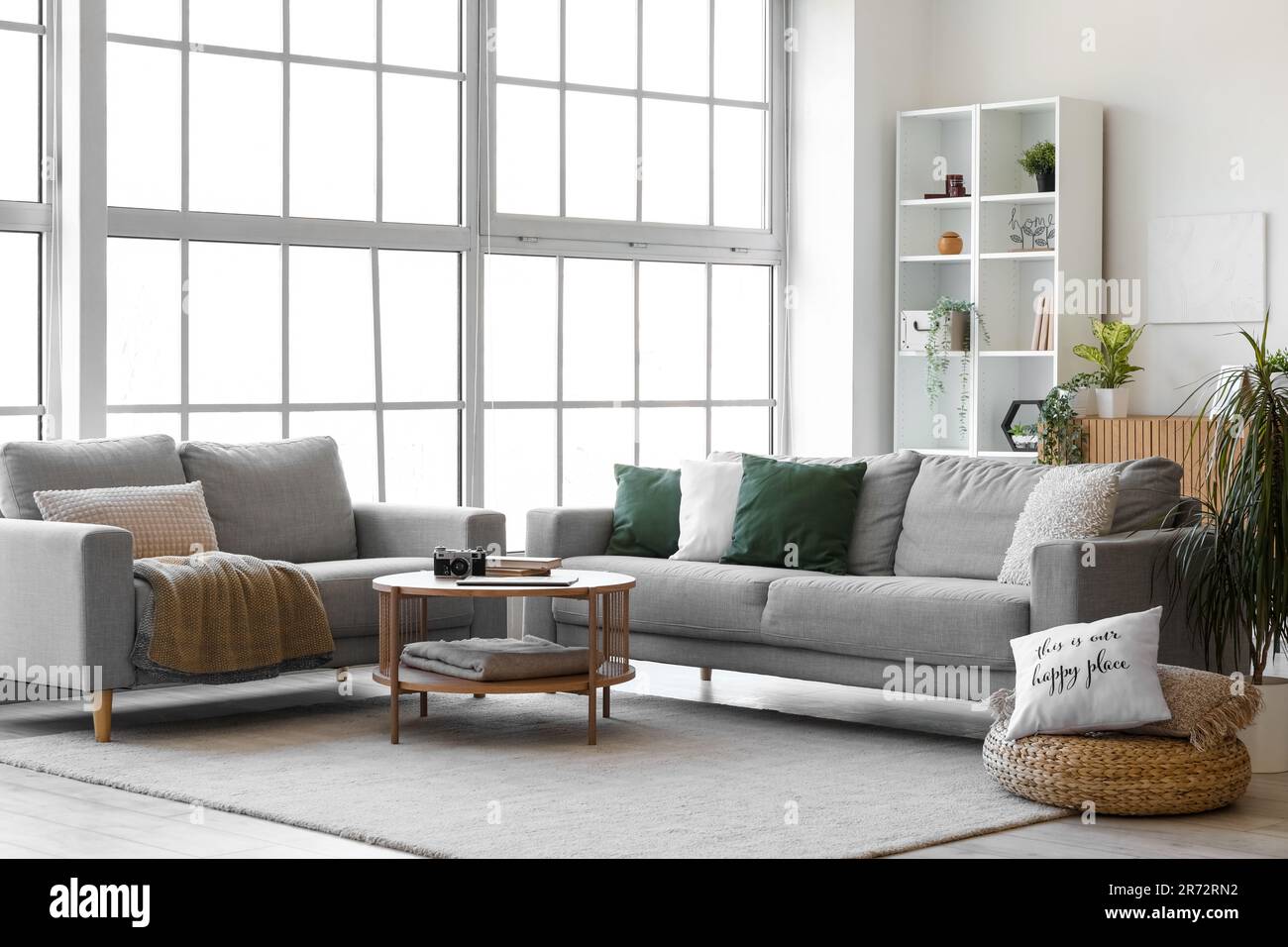 Interior of bright living room with cozy grey sofas and coffee table ...