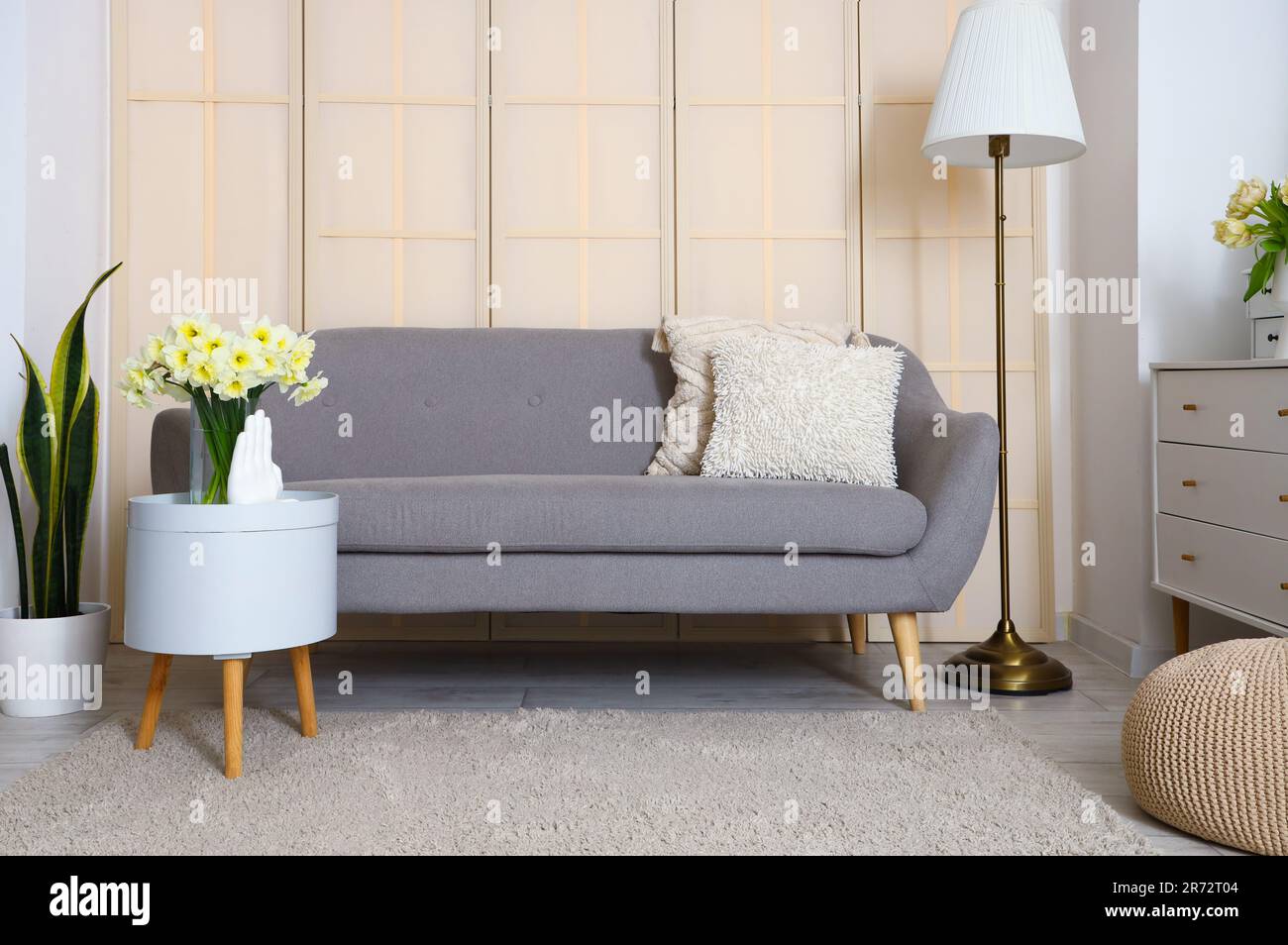 Interior of living room with grey sofa, table and lamp Stock Photo - Alamy