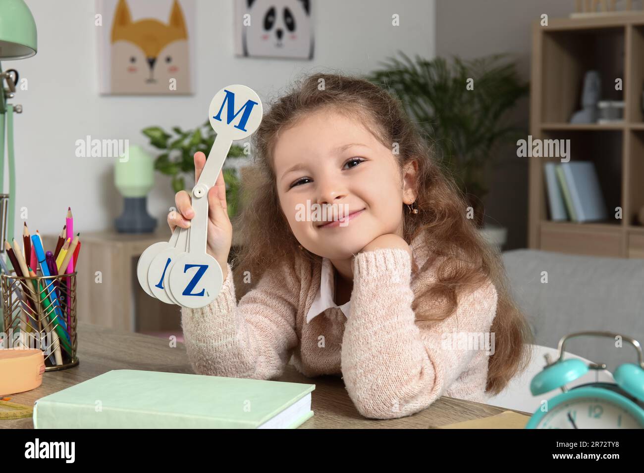 Cute little girl studying with set of letters at home Stock Photo - Alamy