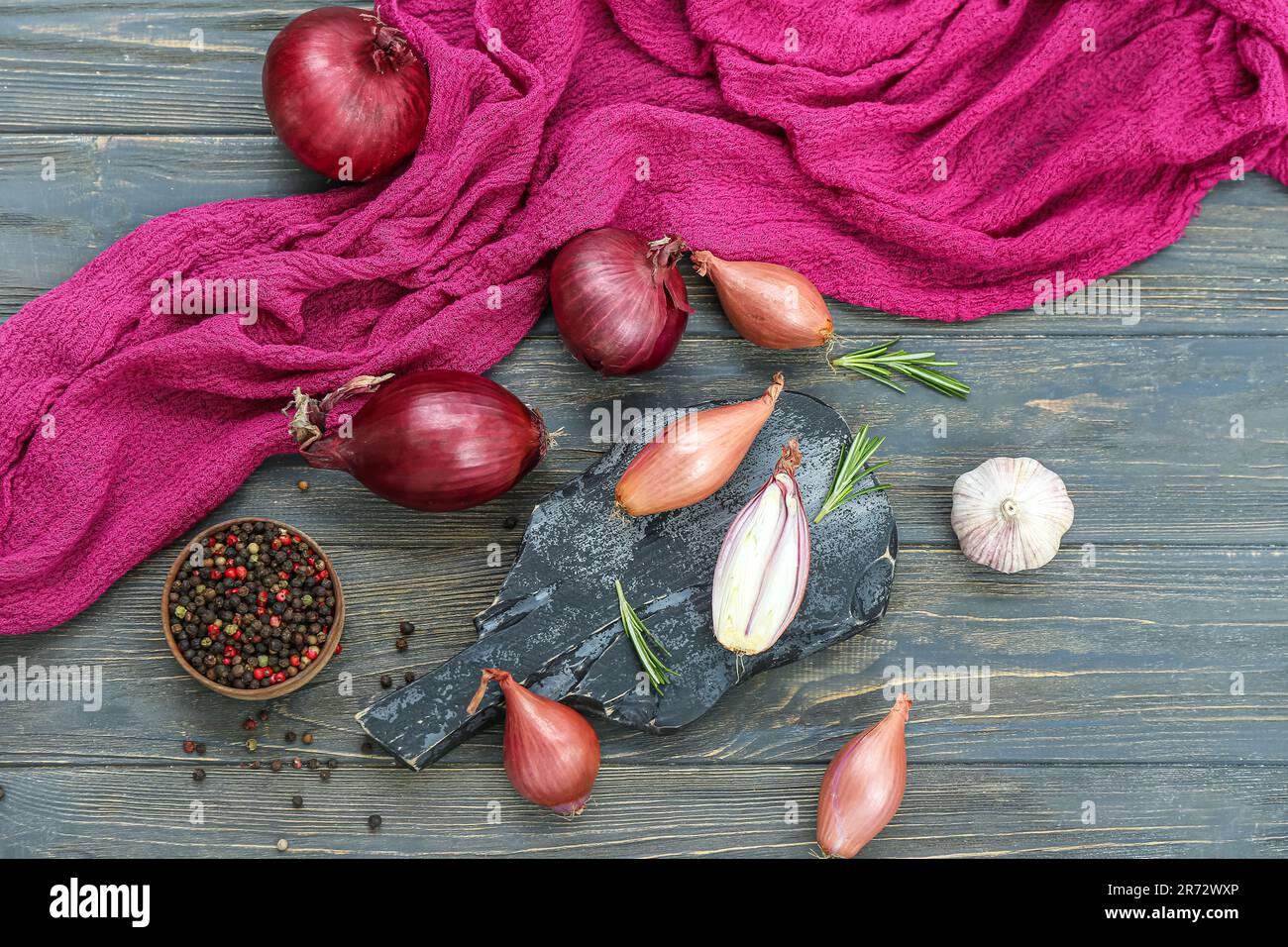 Slate board with different kinds of onion on dark wooden background ...