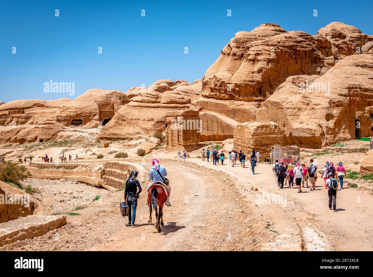 View of the main road to Petra with tourists walking under the hot sun. Stock Photo