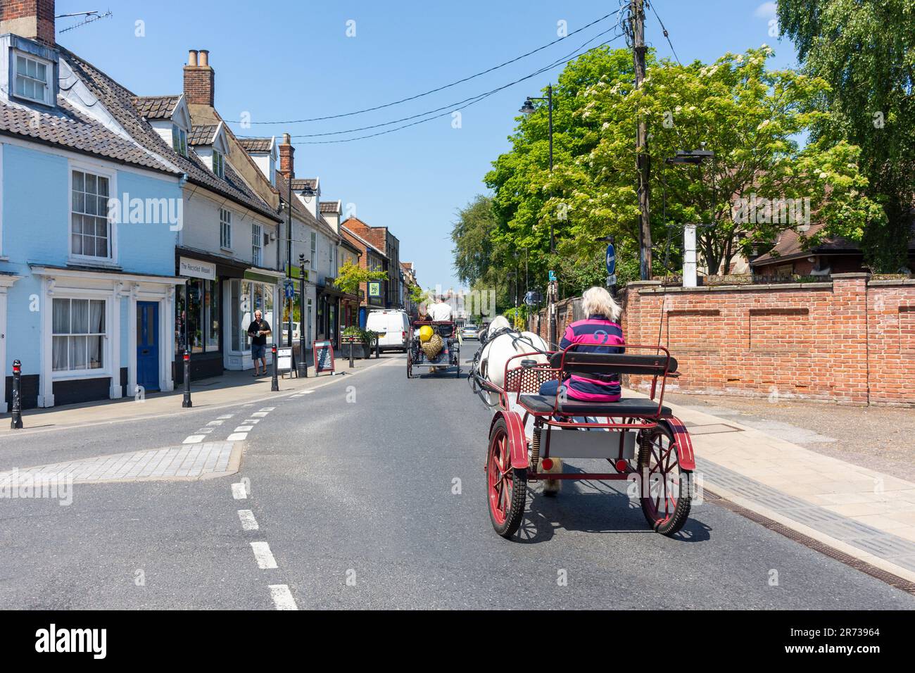 Gypsy traveller horse buggys riding through streets, St Mary's Street, Bungay, Suffolk, England, United Kingdom Stock Photo