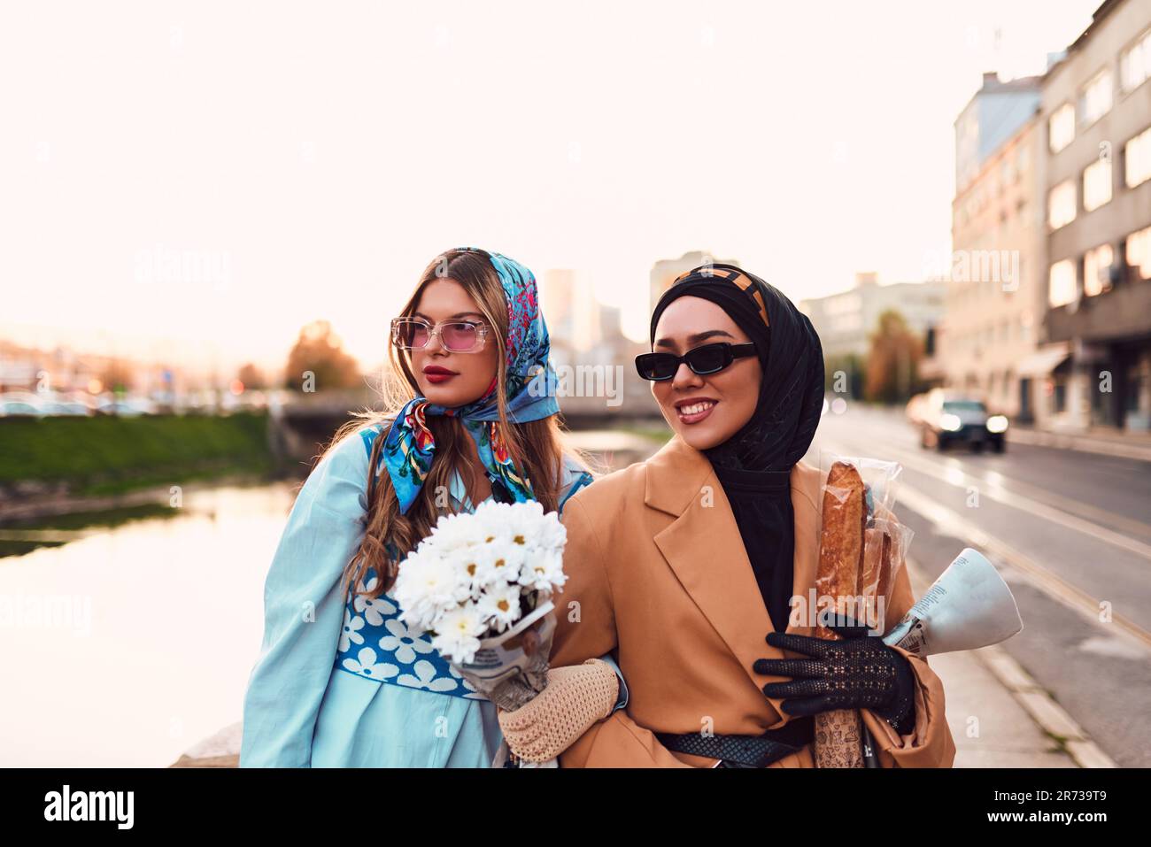 Couple woman one wearing a hijab and a modern yet traditional dress ...