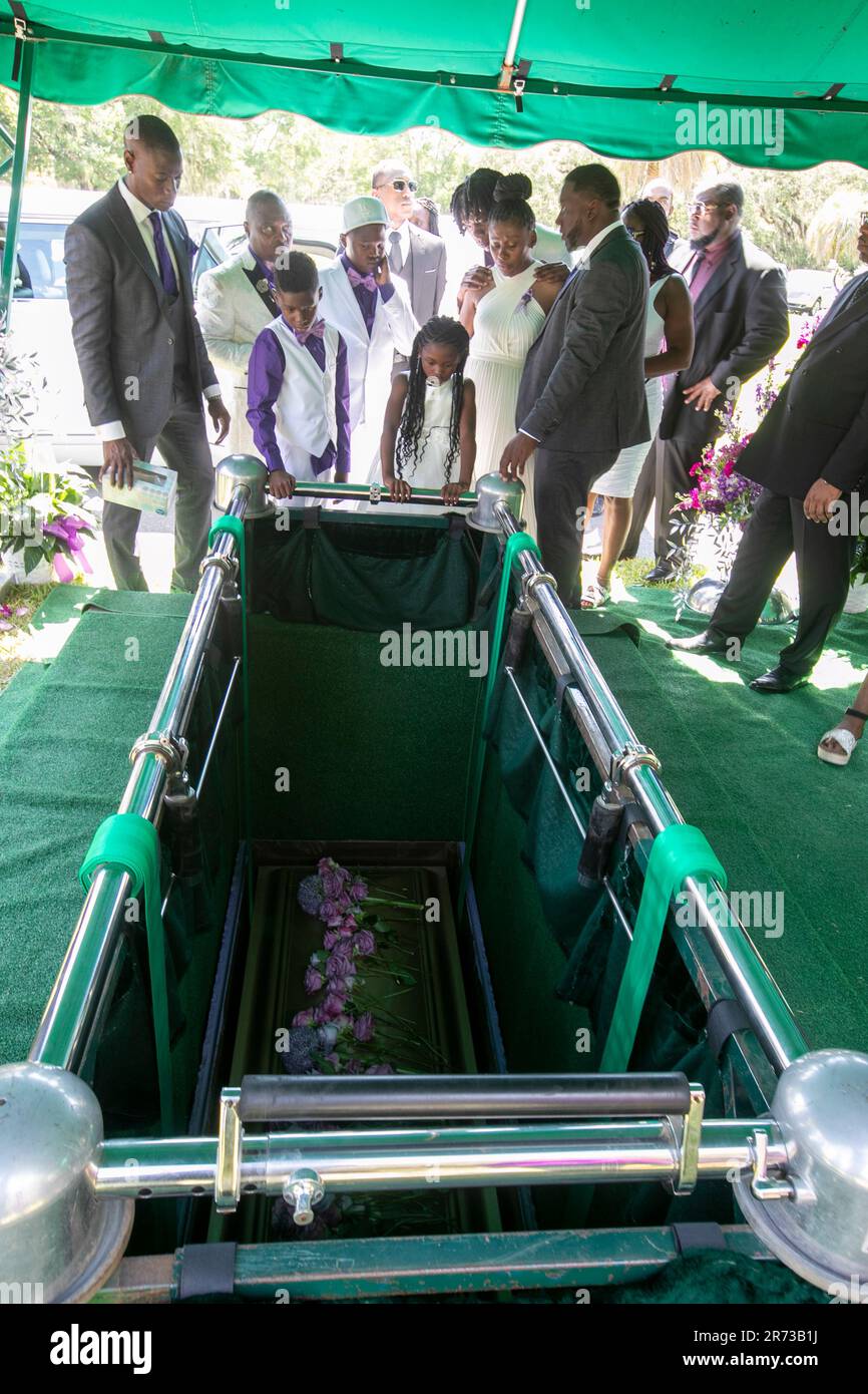 The Owens family looks at the coffin after it was lowered at the grave