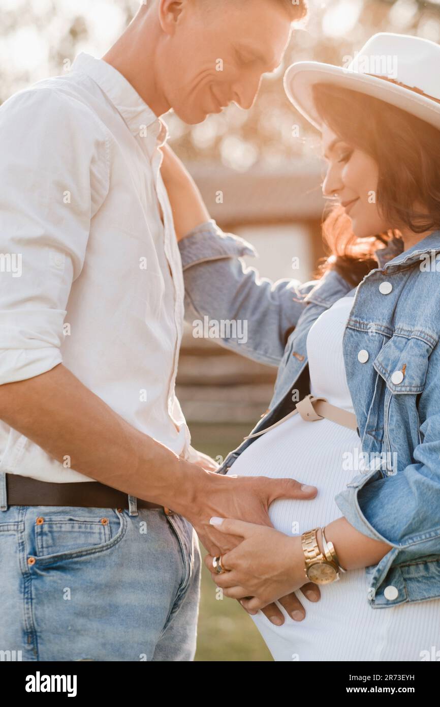 Happy man hugs his pregnant woman's belly at sunset Stock Photo - Alamy